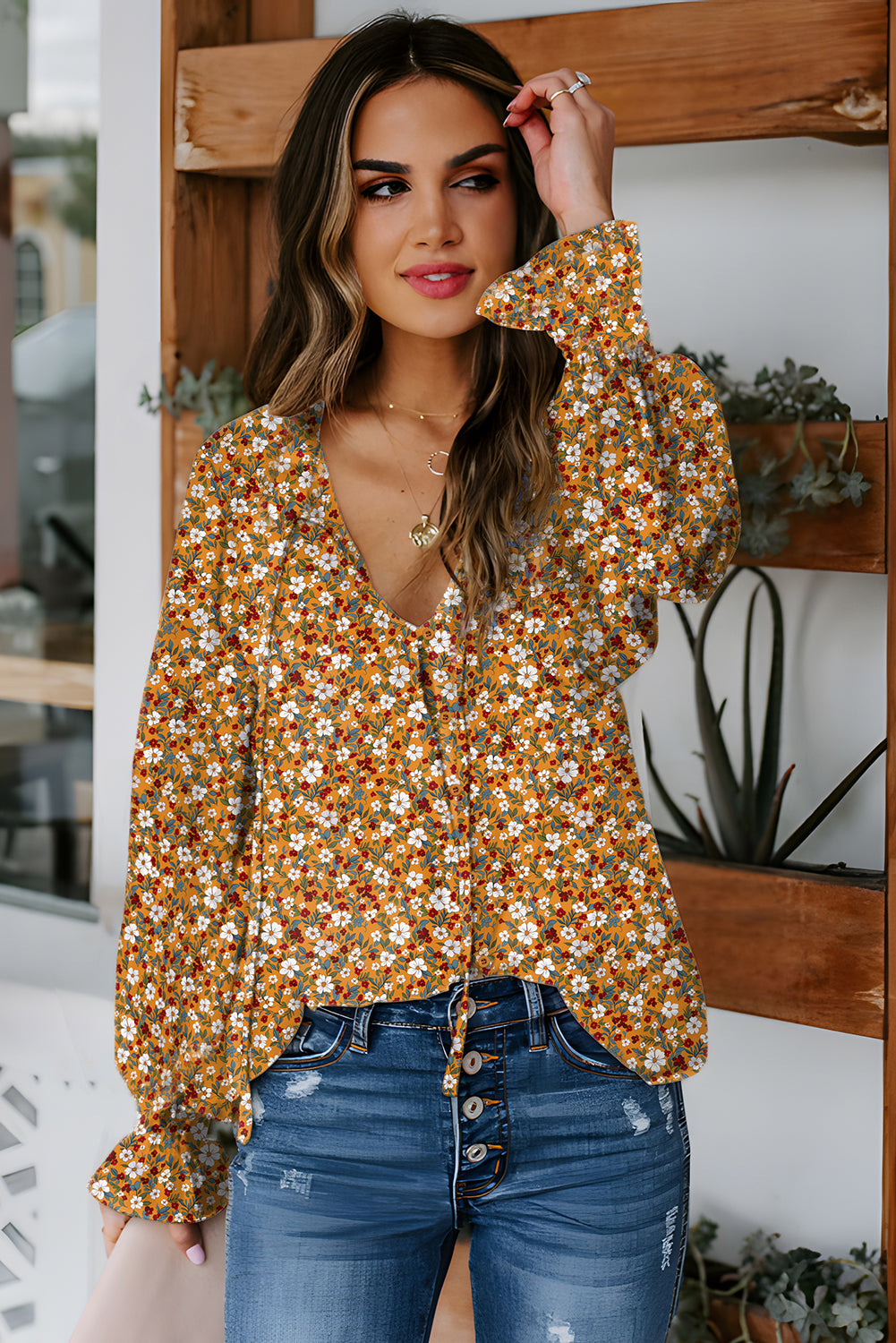 Orange floral ruffled bubble sleeve V-neck blouse from Chic Speak Boutique, featuring a vibrant pattern and feminine design.