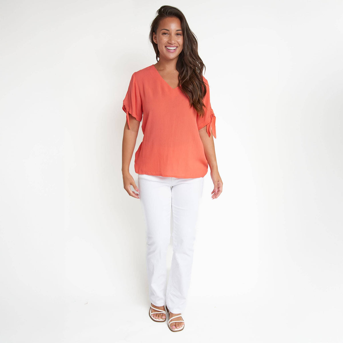 Elsie & Zoey Nika Crepe tied short sleeve V-neck blouse with feminine design and lightweight fabric, displayed on a hanger.