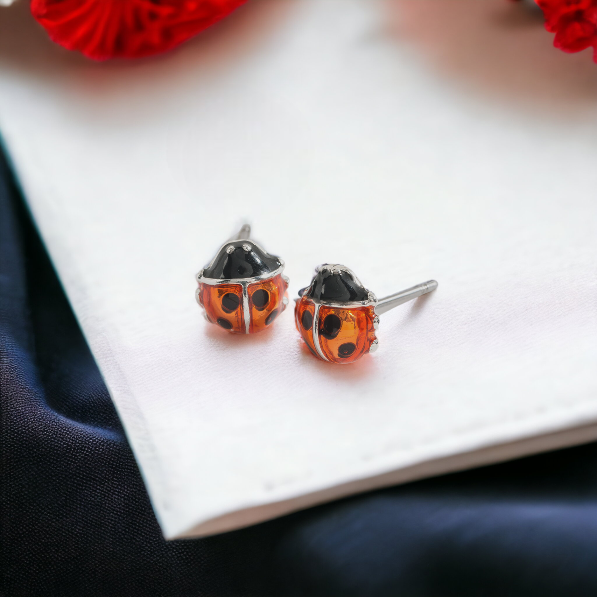 Red and black ladybug ear stud earrings by Howard's featuring cute ladybug designs on silver posts.