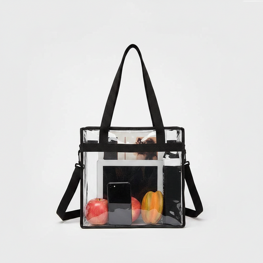 Clear handbag with black straps containing apples on a white background