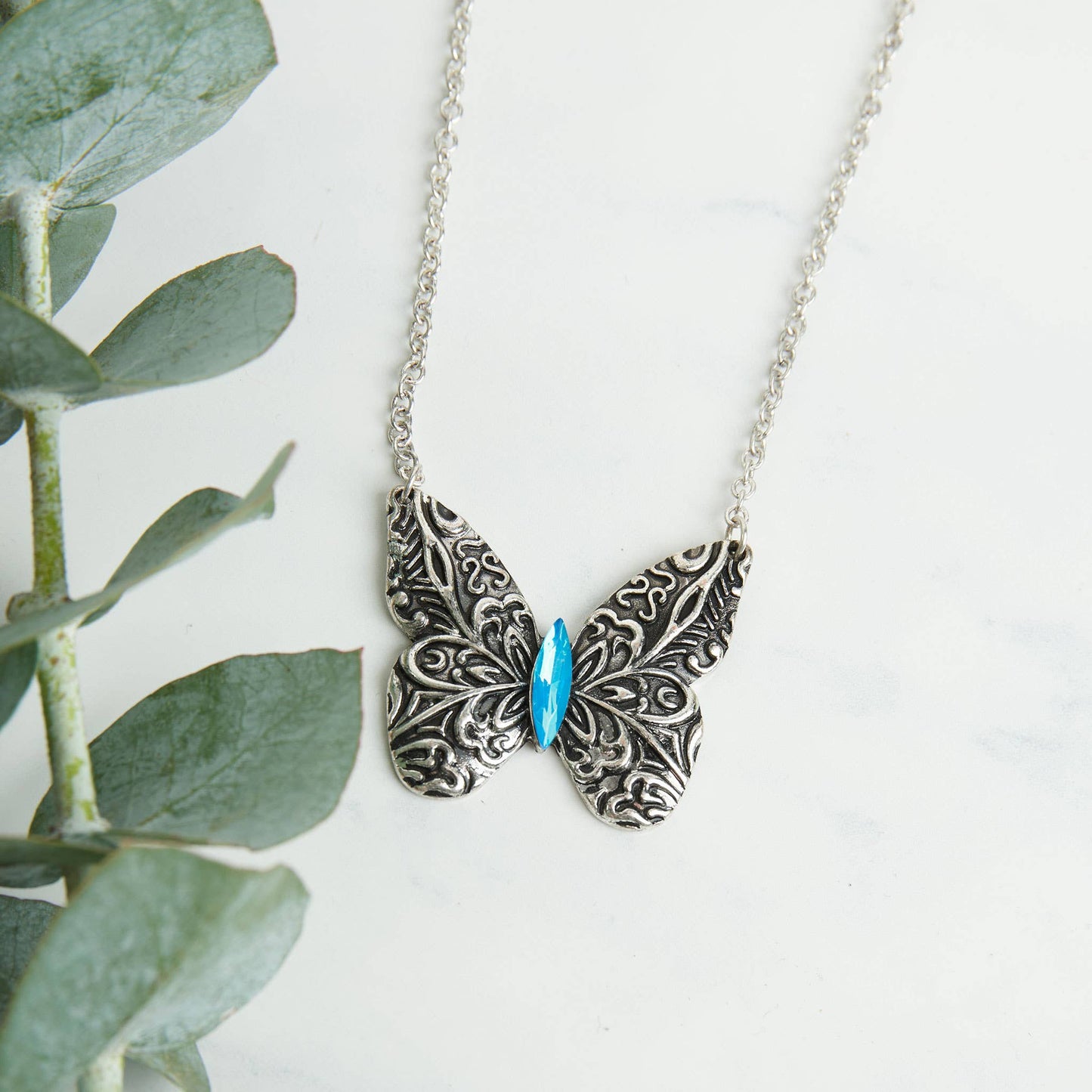 Antique silver butterfly pendant necklace with engraved details on an 18-inch chain, featuring a Howard's Zenni design.