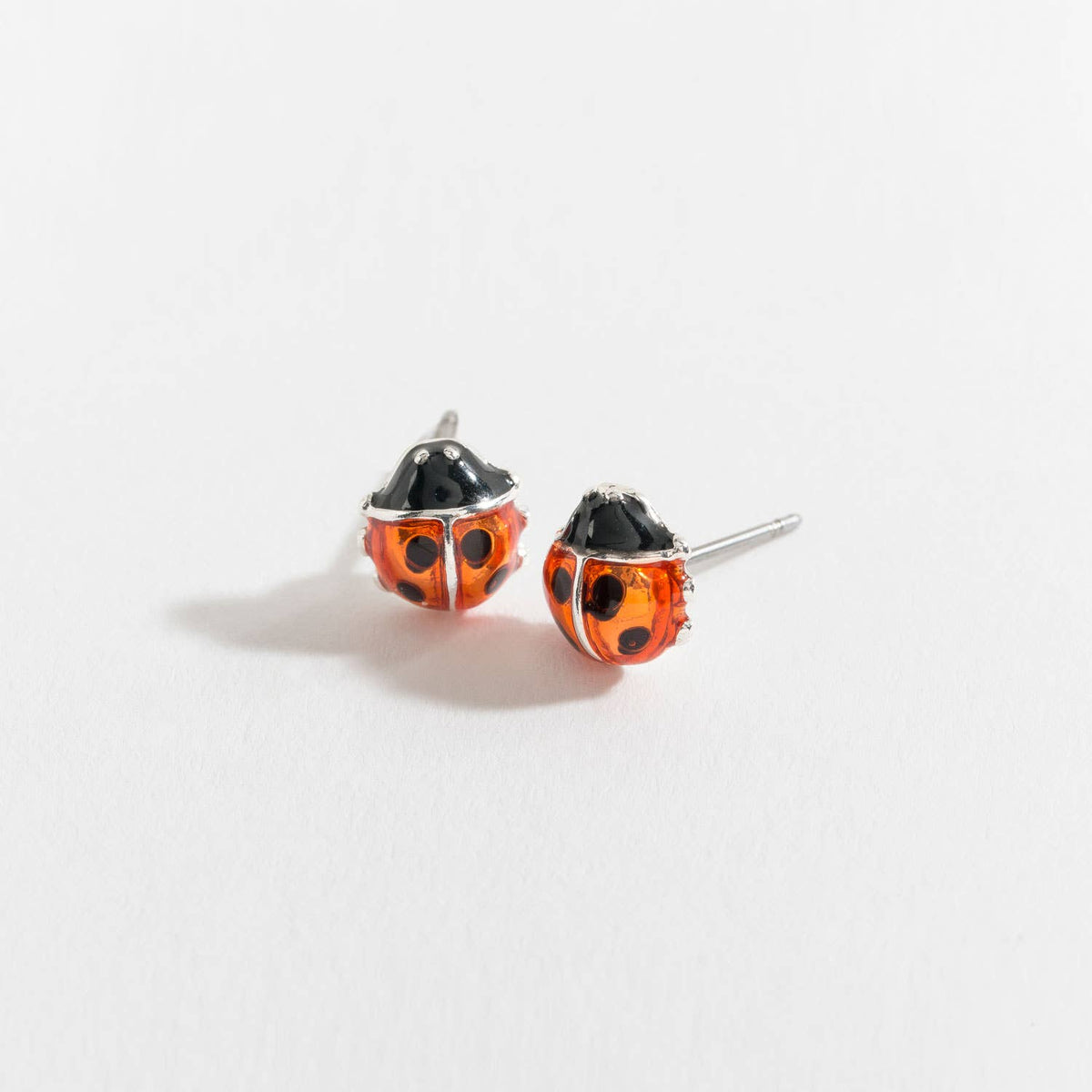 Red and black ladybug stud earrings from Howard's featuring detailed ladybug ear designs on a white background