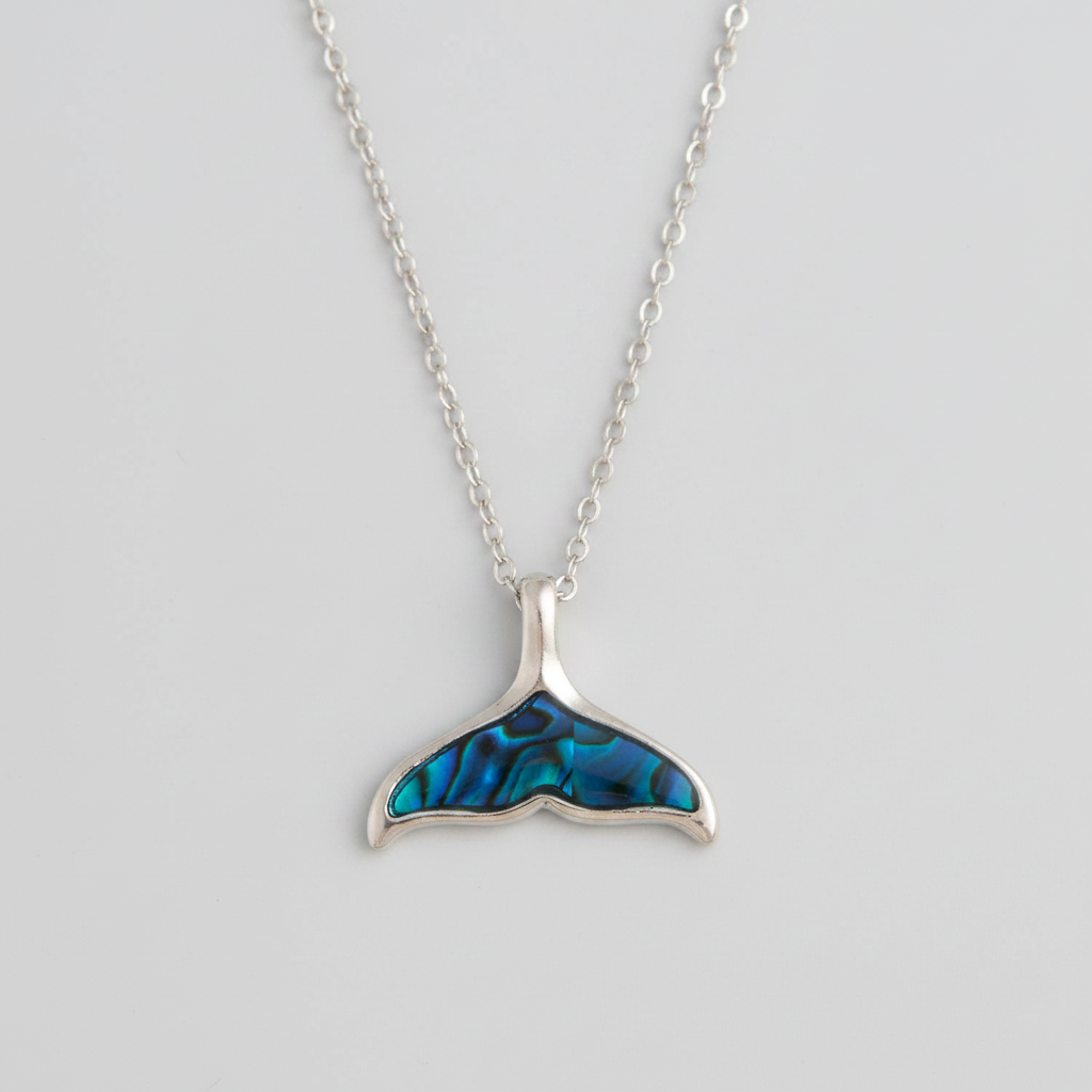 Silver necklace with a blue whale tail pendant on a light gray background