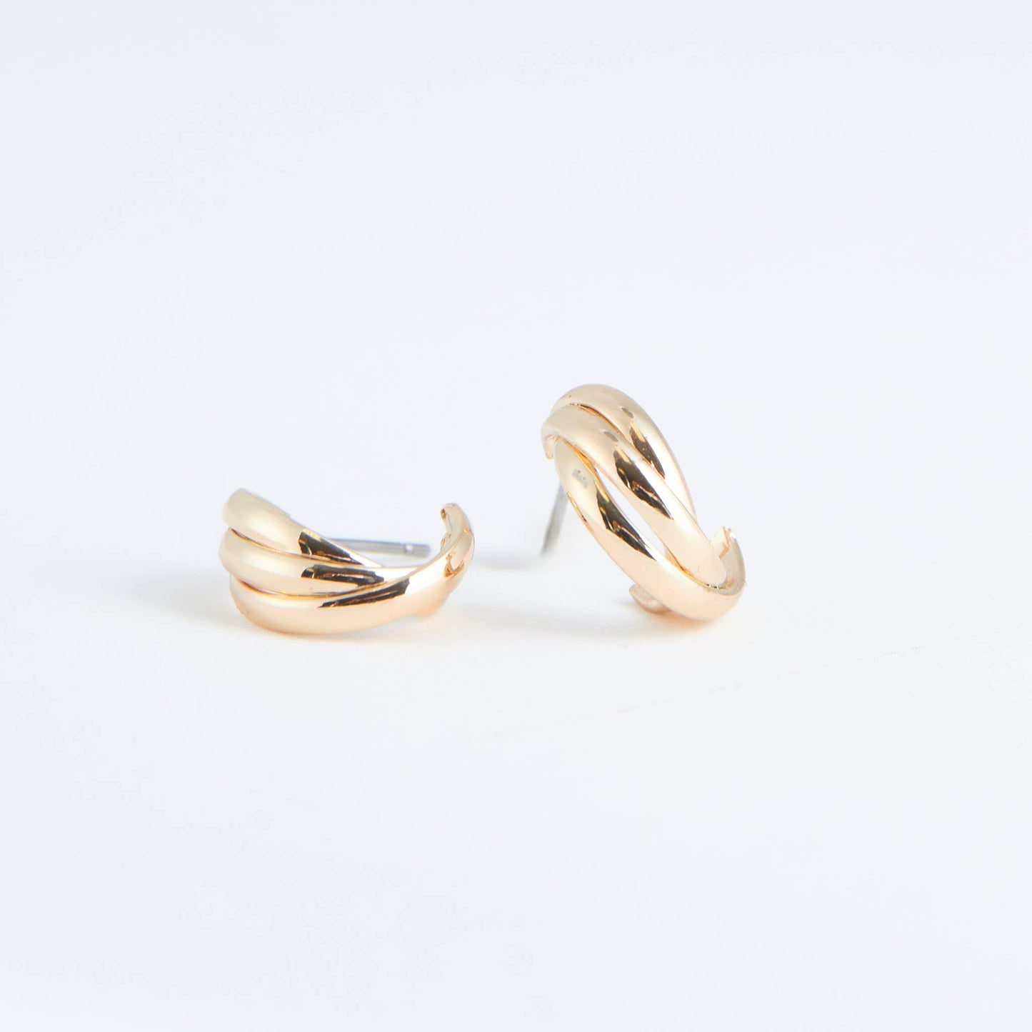 Pair of gold hoop earrings on a light gray background