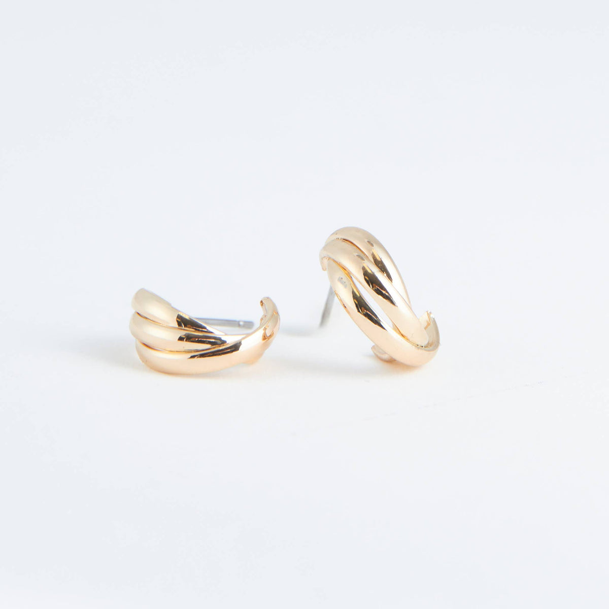 Pair of gold hoop earrings on a light gray background