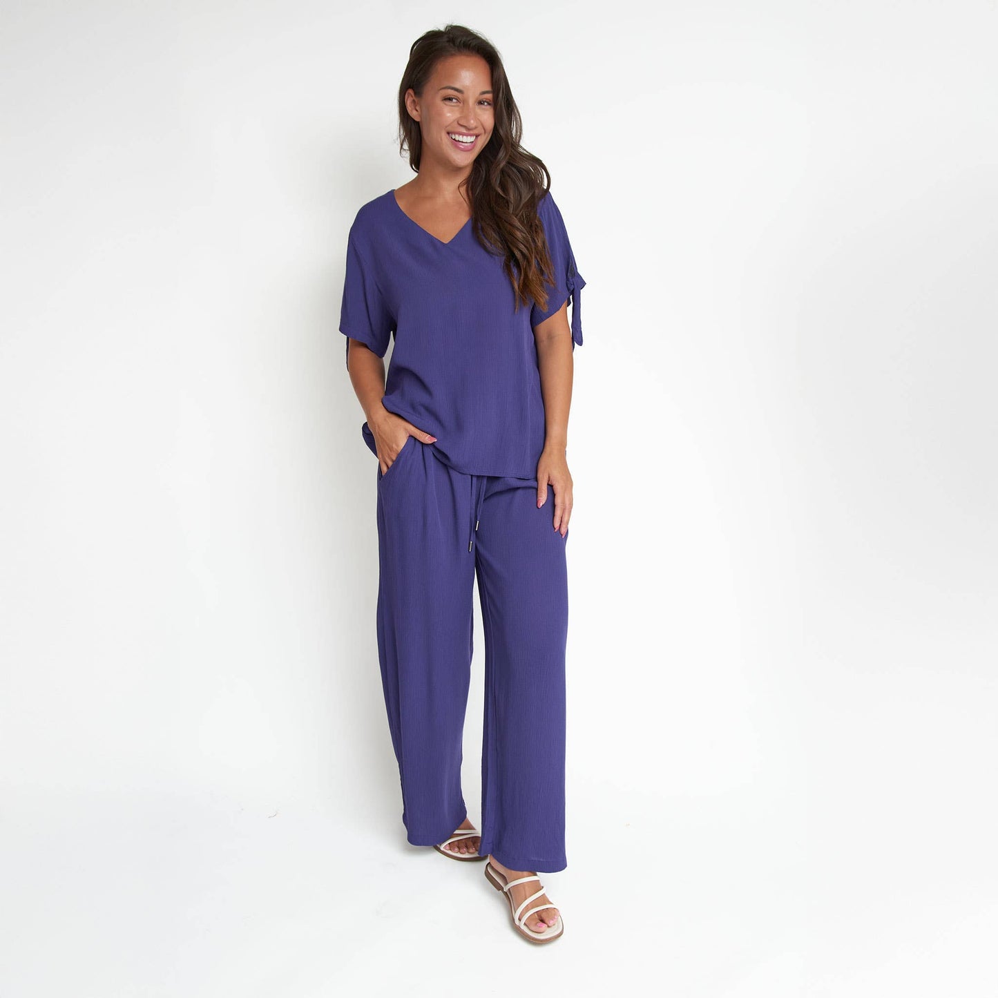 Elsie & Zoey Nika Crepe Tied Short Sleeve V-Neck Blouse, stylish blouse with short sleeves and V-neck, fabric appears lightweight and textured.