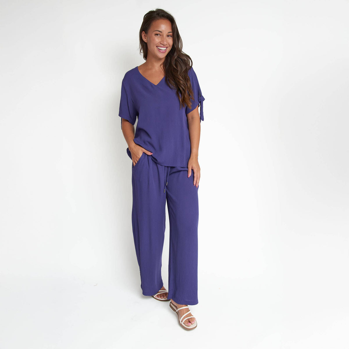 Elsie & Zoey Nika Crepe Tied Short Sleeve V-Neck Blouse, stylish blouse with short sleeves and V-neck, fabric appears lightweight and textured.