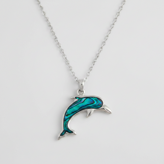 Dolphin-shaped pendant on a chain against a light gray background