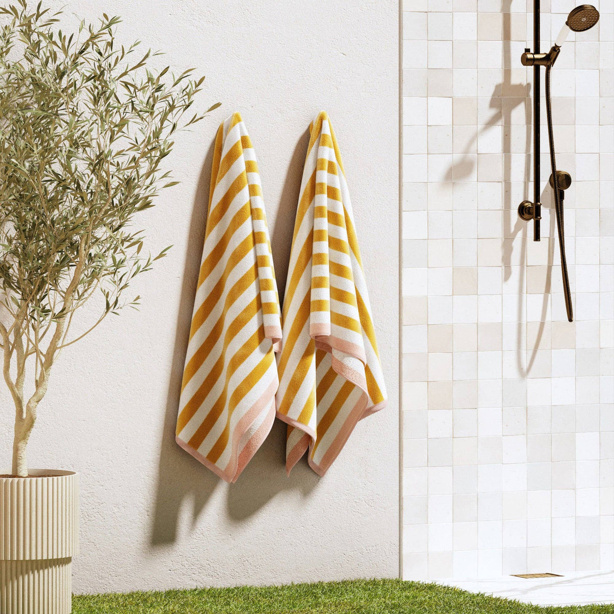 Oversized striped border Santa Cruz beach towel by BH Collective showing vibrant blue, white, and yellow stripes on soft terry fabric.