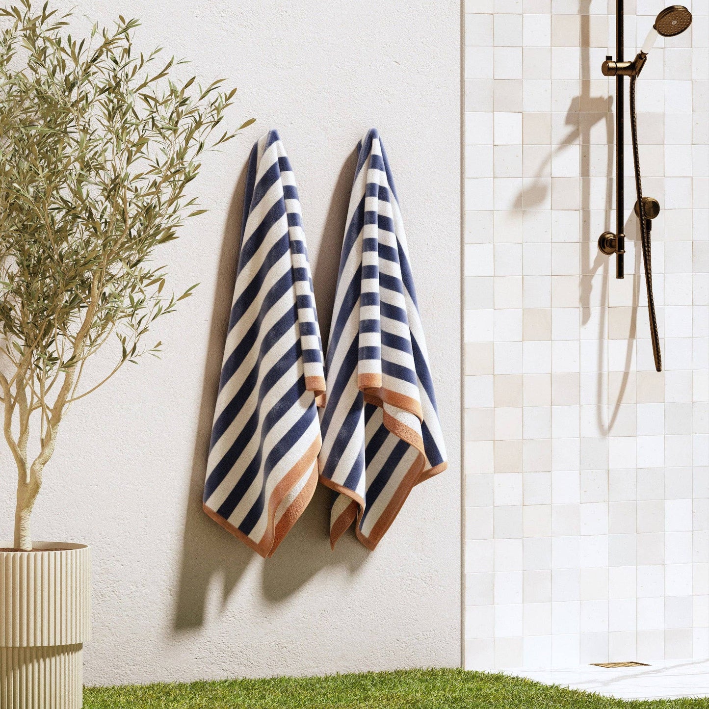 BH Collective oversized striped border cabana beach towel with colorful blue, white, and red stripes, ideal for beach lounging.