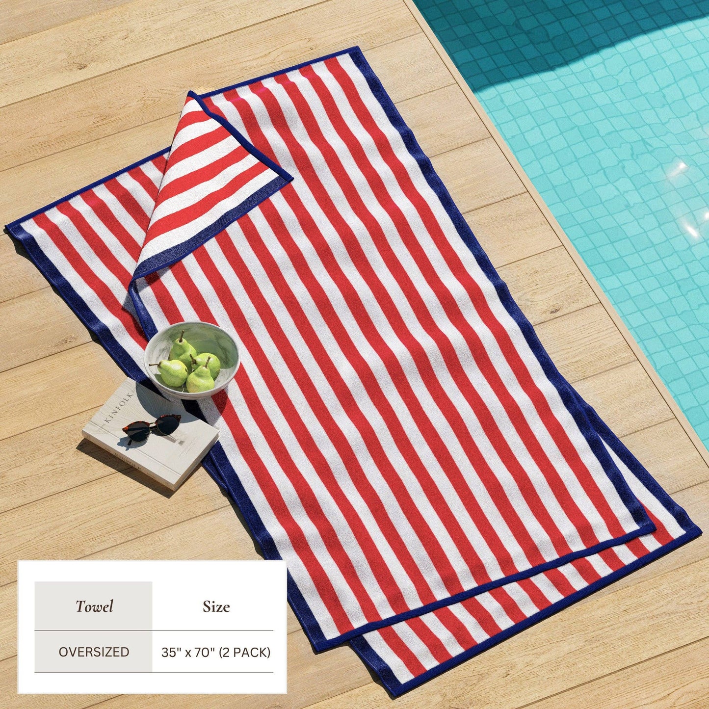 Oversized Santa Cruz striped border cabana beach towel by BH Collective laid on sandy beach with ocean background.