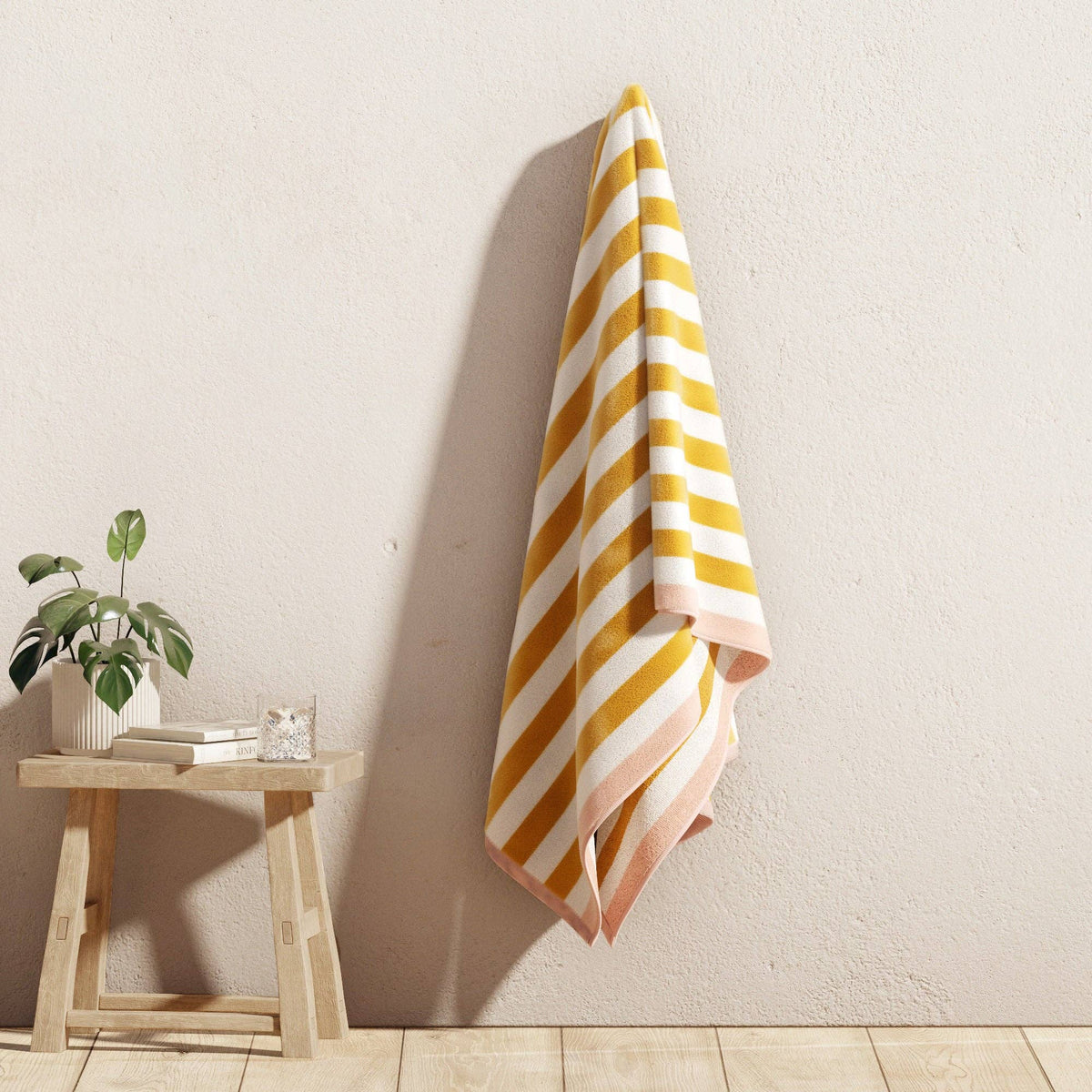 BH Collective oversized striped border cabana beach towel with vibrant colors, perfect for lounging at Santa Cruz beach.