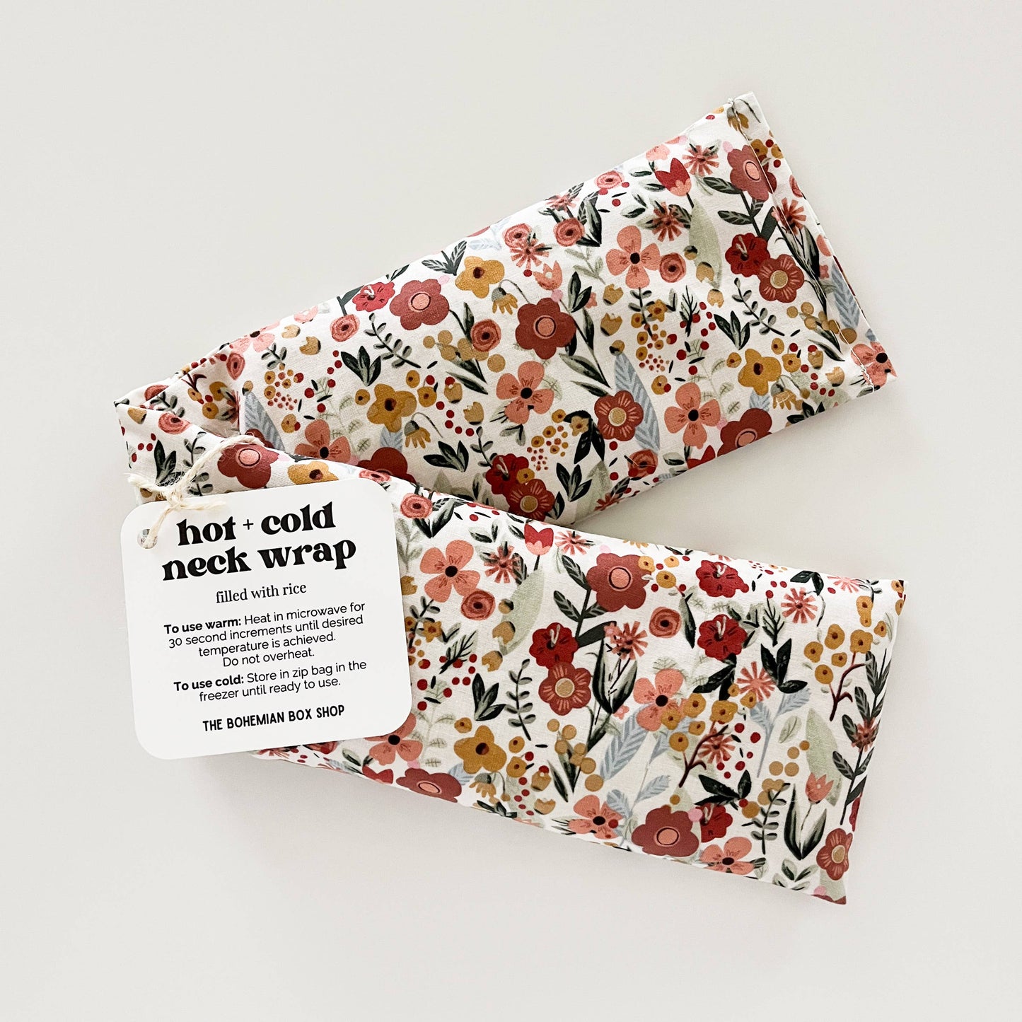 Bohemian Box Shop Earth Botanicals hot and cold therapy neck wrap with floral design and adjustable strap for soothing relief.