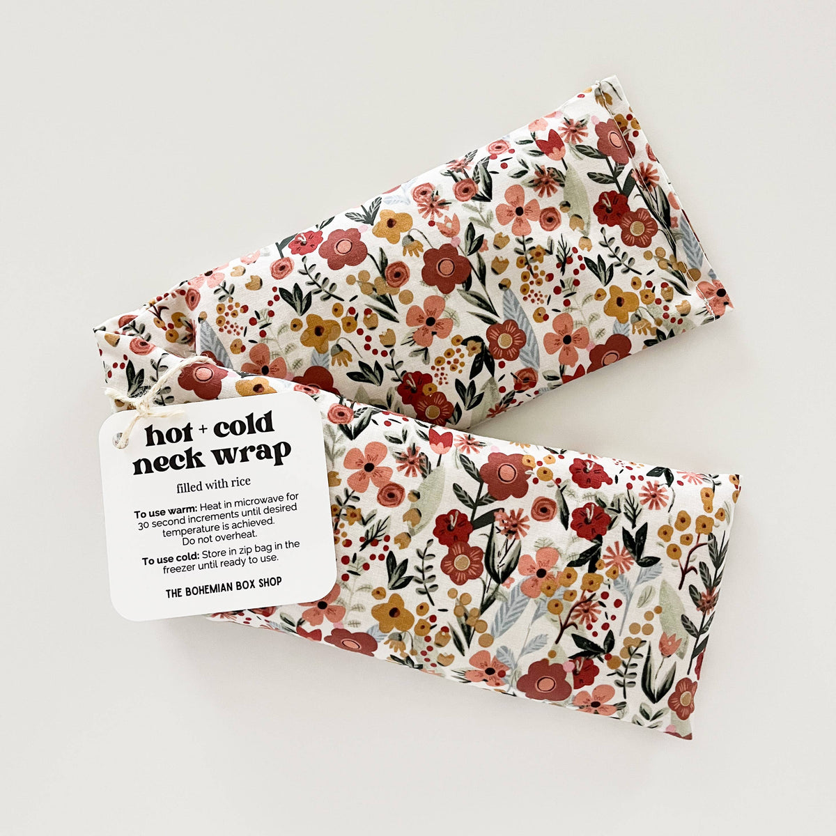 Bohemian Box Shop Earth Botanicals hot and cold therapy neck wrap with floral design and adjustable strap for soothing relief.