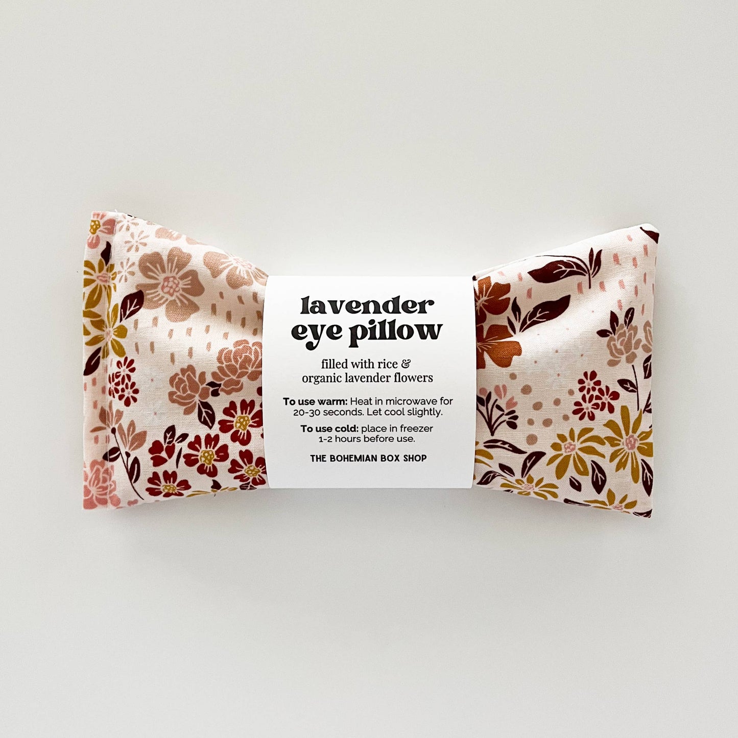 Lavender eye pillow with earth tone floral patterns from Bohemian Box Shop, soft fabric and calming design for relaxation.