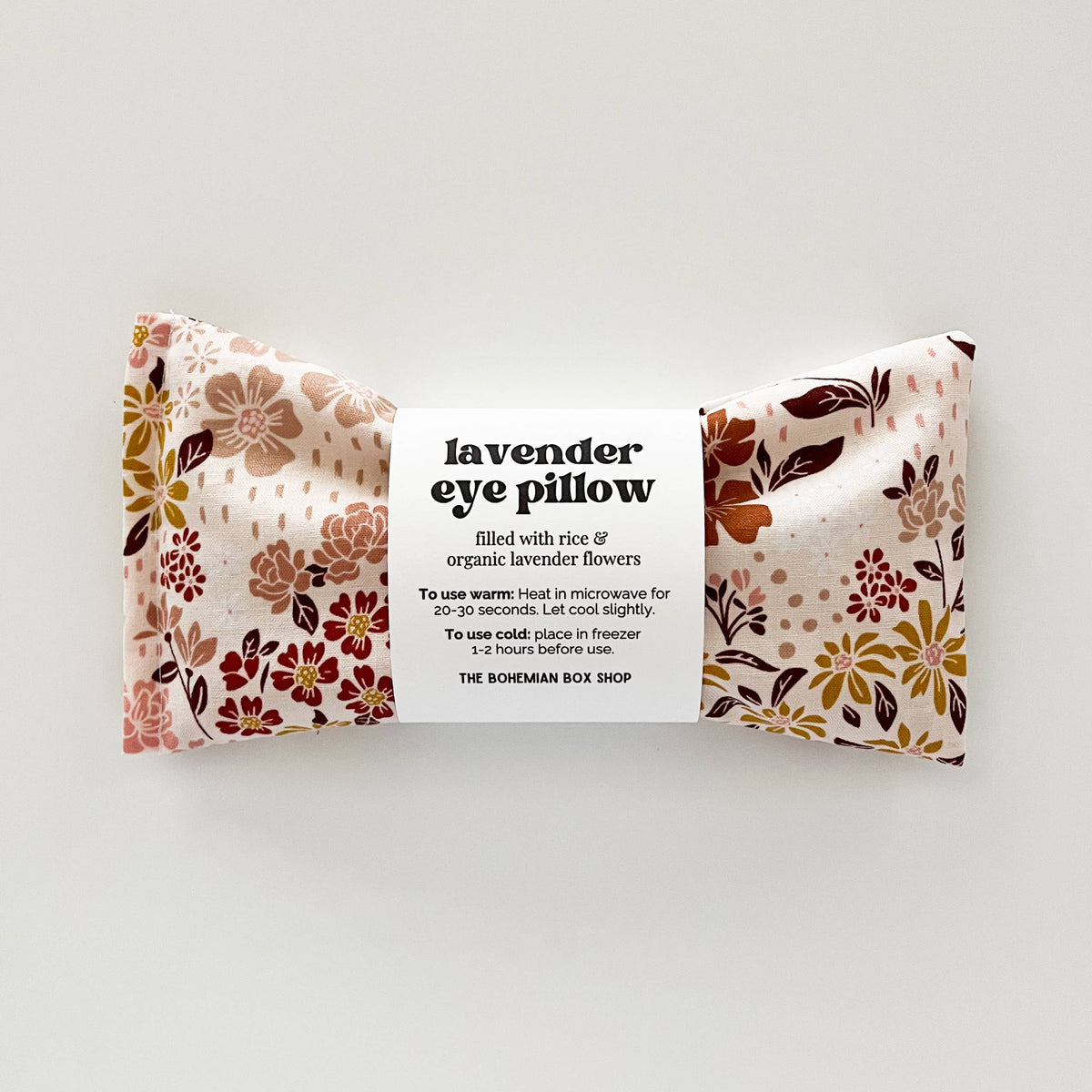 Lavender eye pillow with earth tone floral patterns from Bohemian Box Shop, soft fabric and calming design for relaxation.