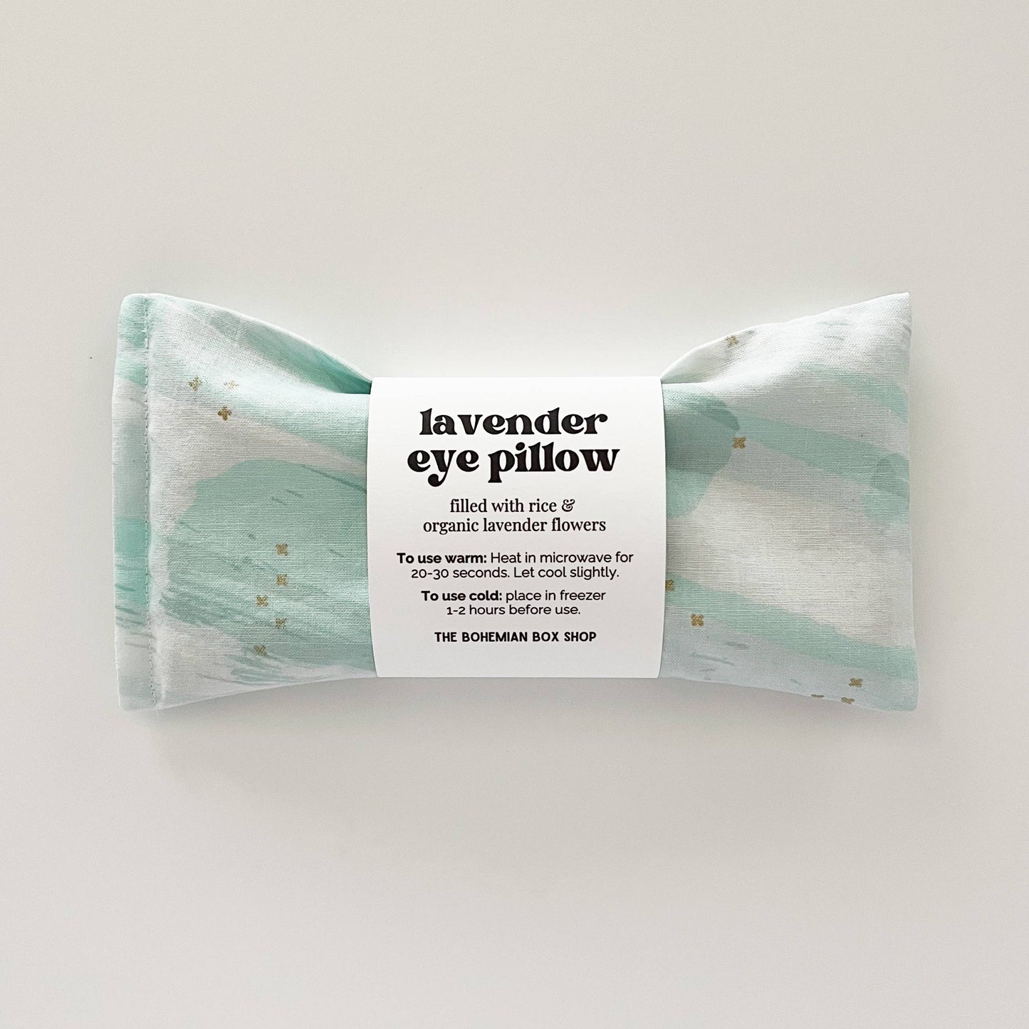 Lavender eye pillow with mint, white, and gold star patterns from Bohemian Box Shop, featuring soft fabric and decorative design.