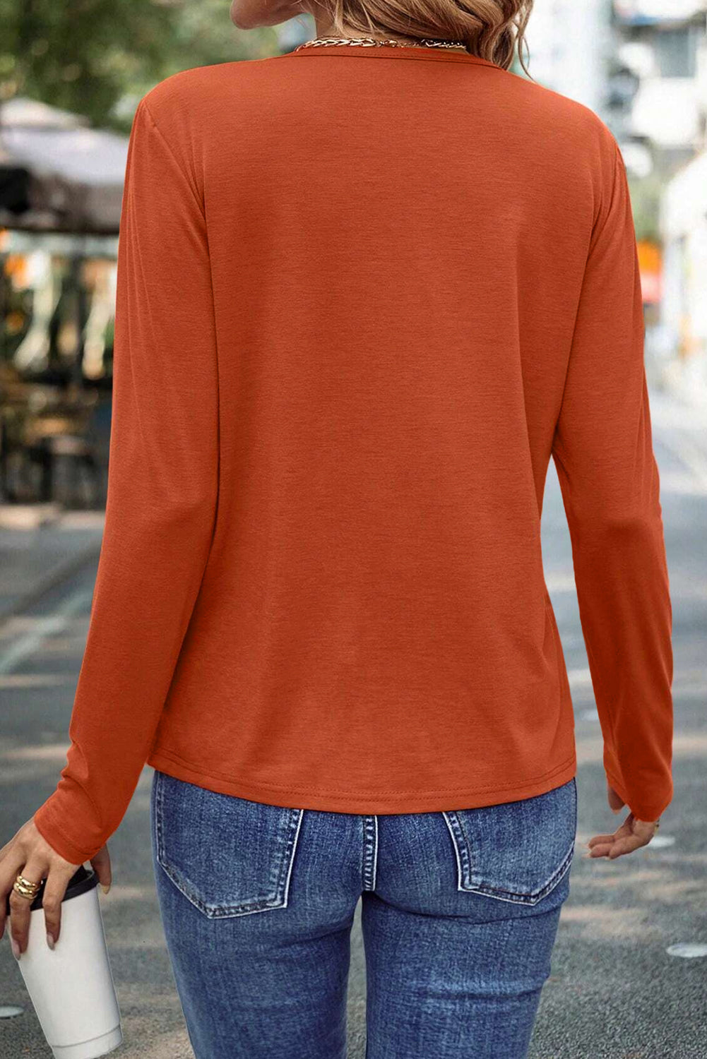 Burnt orange asymmetric long-sleeve top with seam detail from Chic Speak Boutique, casual style with unique design elements.