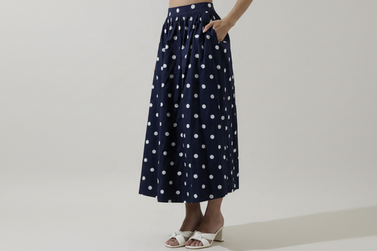 Caryn polka dot skirt by SugarLips featuring a flowy design with black and white dots, styled with a casual top.
