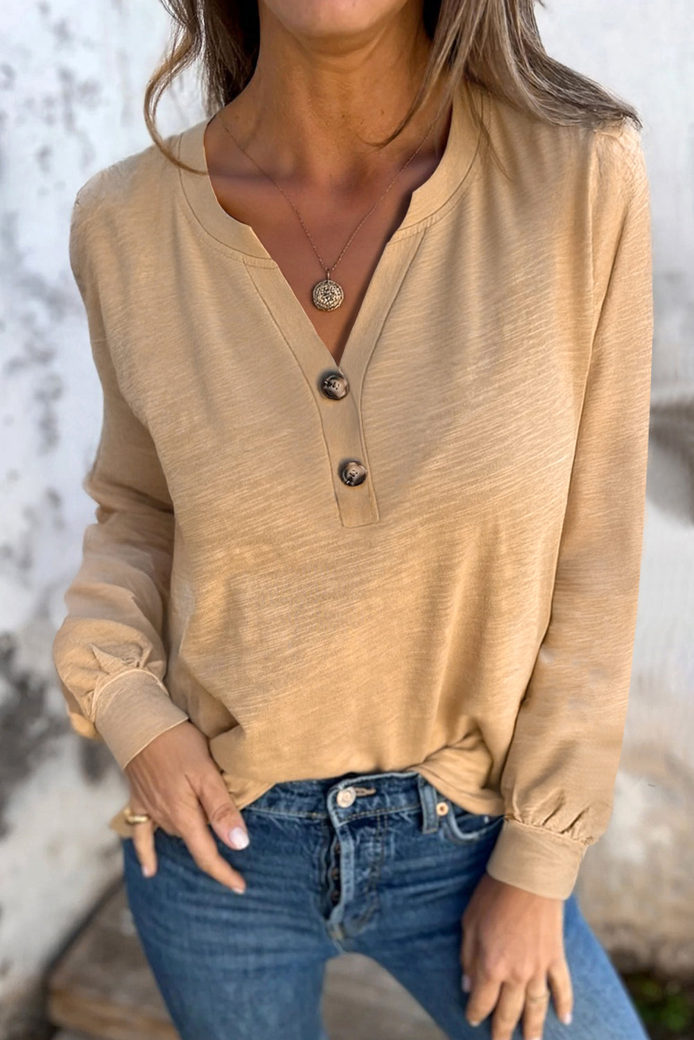 Beige long sleeve V-neck top from Chic Speak Boutique, shown on a hanger highlighting the soft fabric and fitted style.
