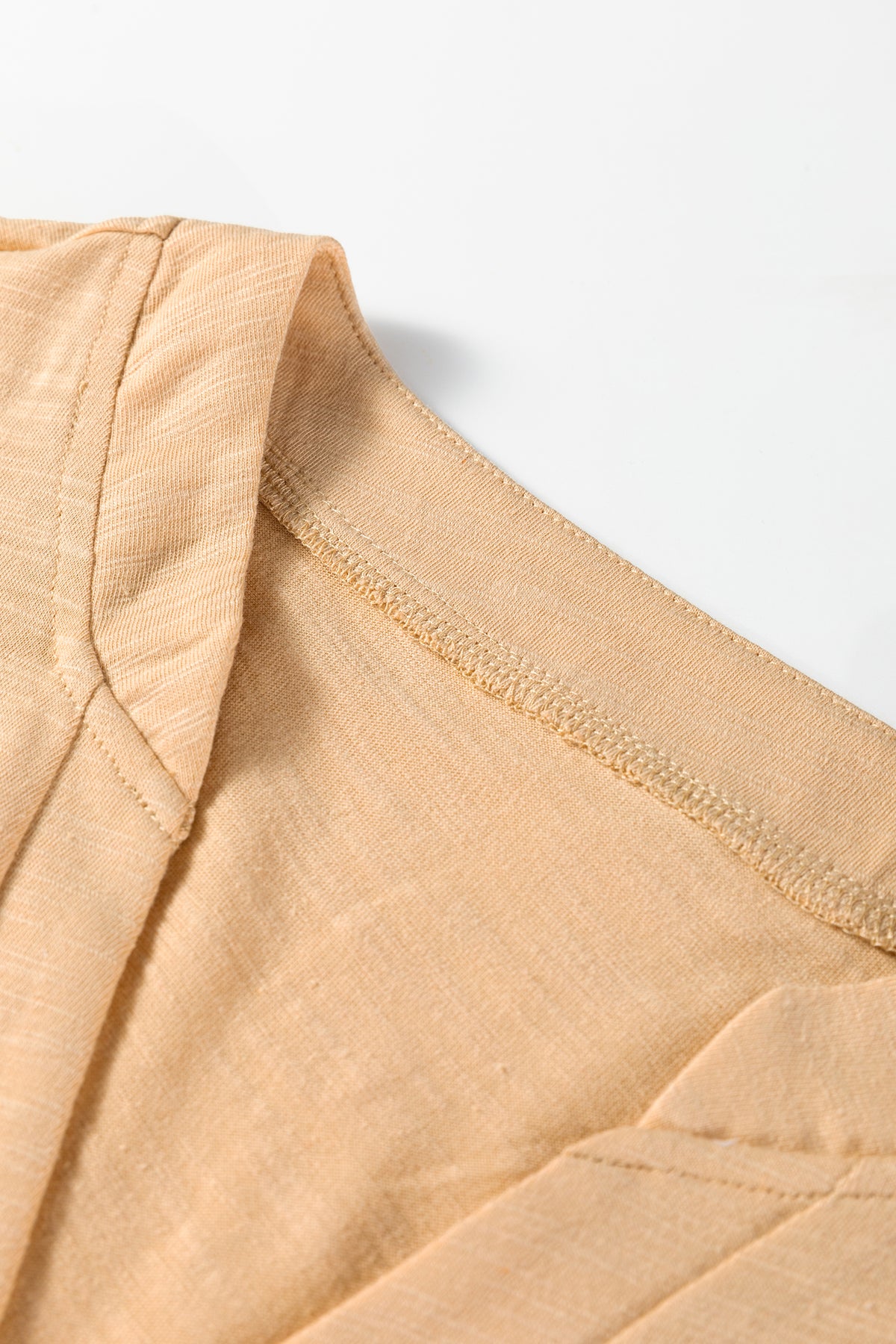Beige long sleeve V-neck top from Chic Speak Boutique, displayed flat with soft fabric and fitted silhouette.