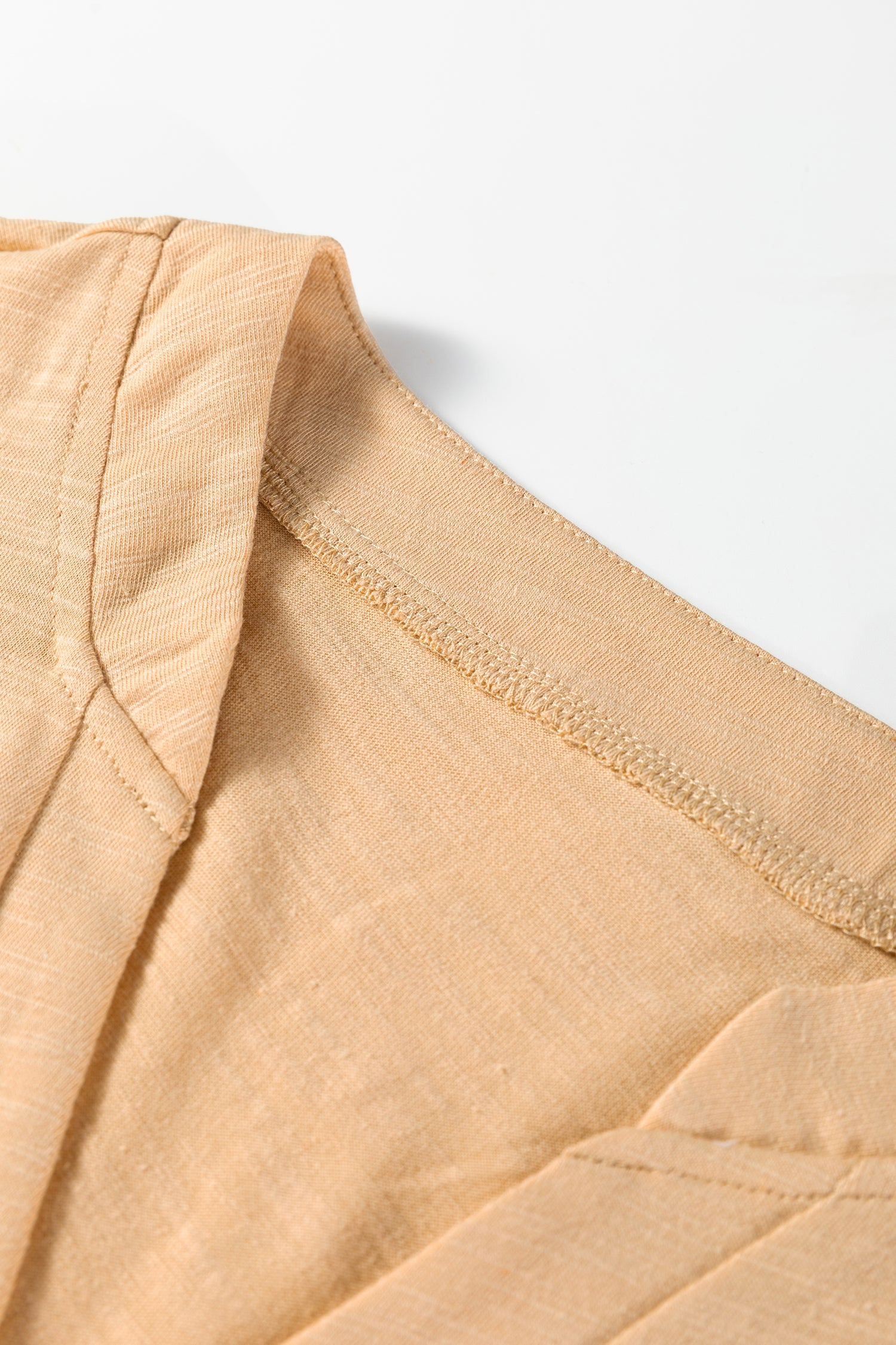 Beige long sleeve V-neck top from Chic Speak Boutique, displayed flat with soft fabric and fitted silhouette.