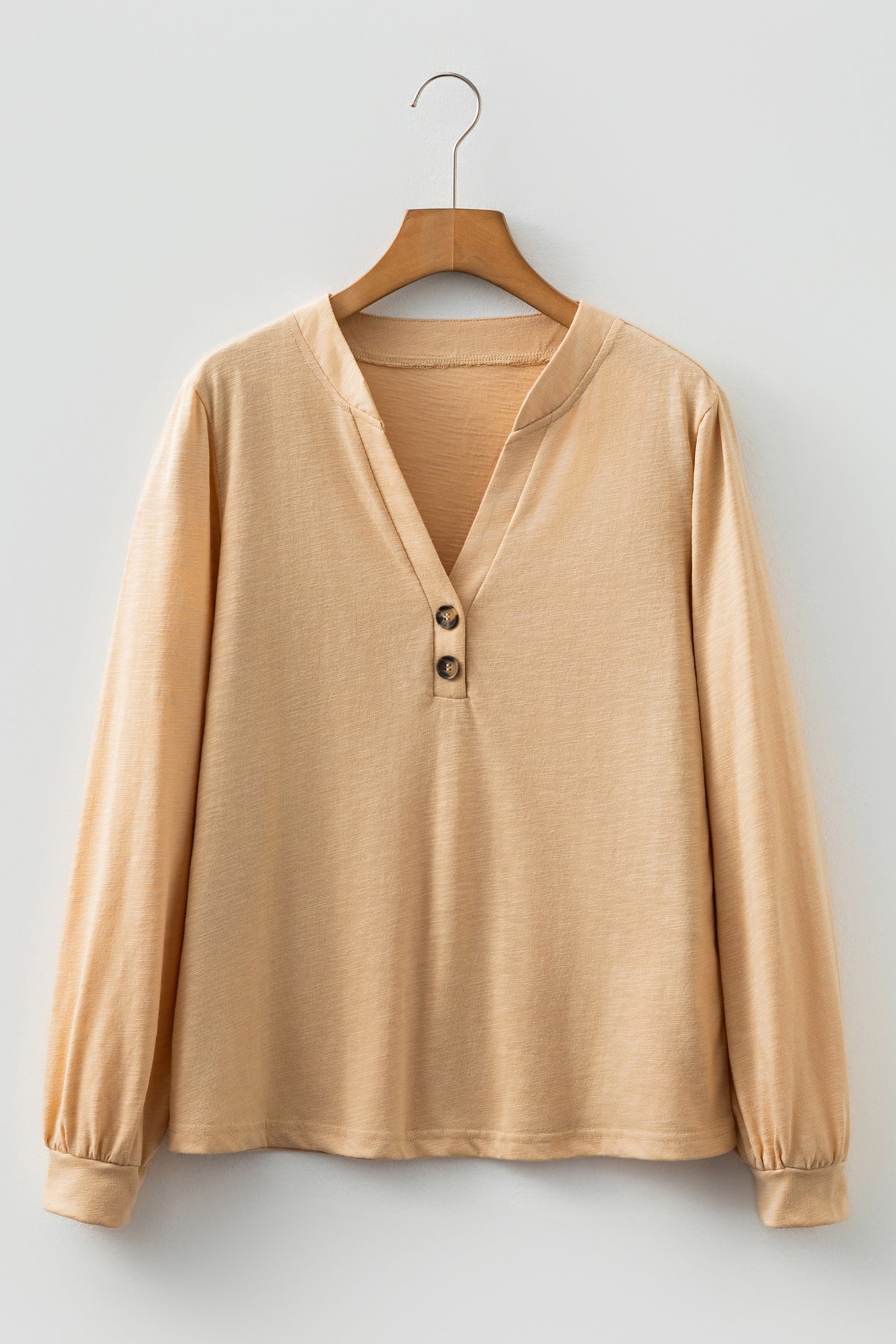 Beige long sleeve V-neck top by Chic Speak Boutique, featuring a fitted style and soft fabric, shown on a model.