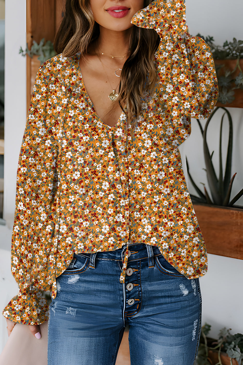 Orange floral ruffled bubble sleeve V-neck blouse from Chic Speak Boutique, featuring a feminine design and ruffle details.