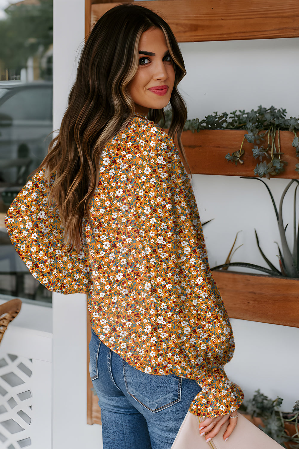 Orange floral ruffled bubble sleeve V-neck blouse by Chic Speak Boutique, showing the detailed ruffle design and floral pattern.