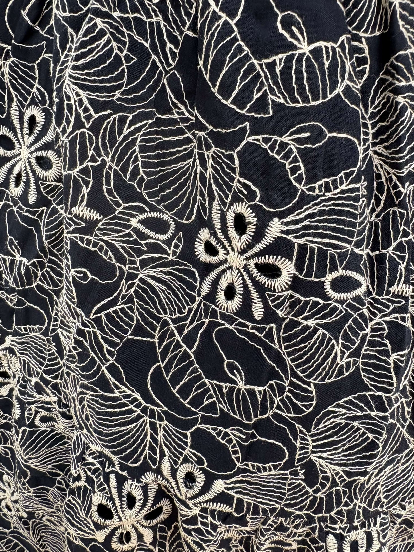 Navy embroidered smocked midi dress by Chic Speak Boutique, showcasing a fitted bodice and flowing skirt with intricate embroidery.