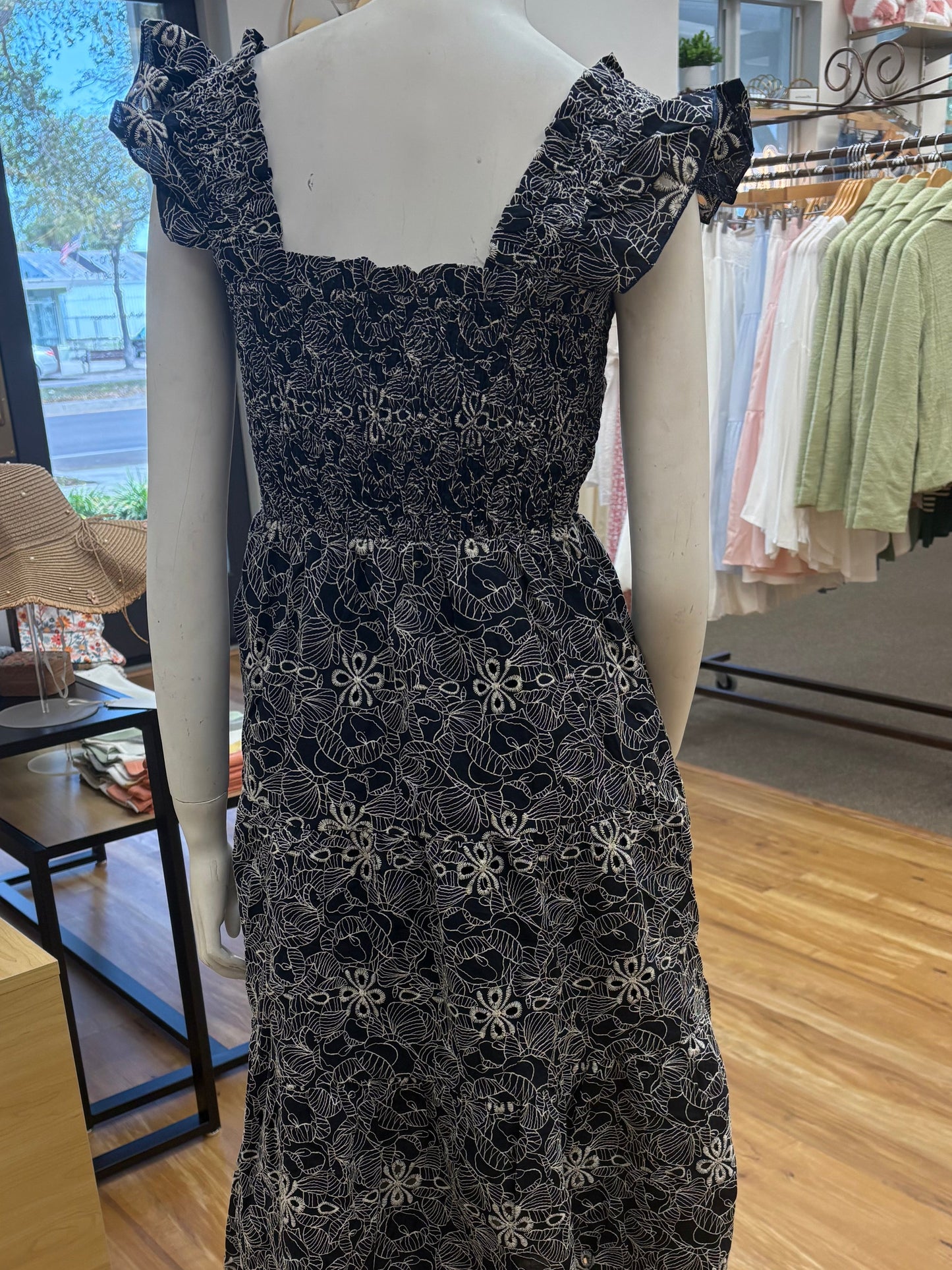 Navy embroidered smocked midi dress from Chic Speak Boutique featuring intricate embroidery and a flowy silhouette.