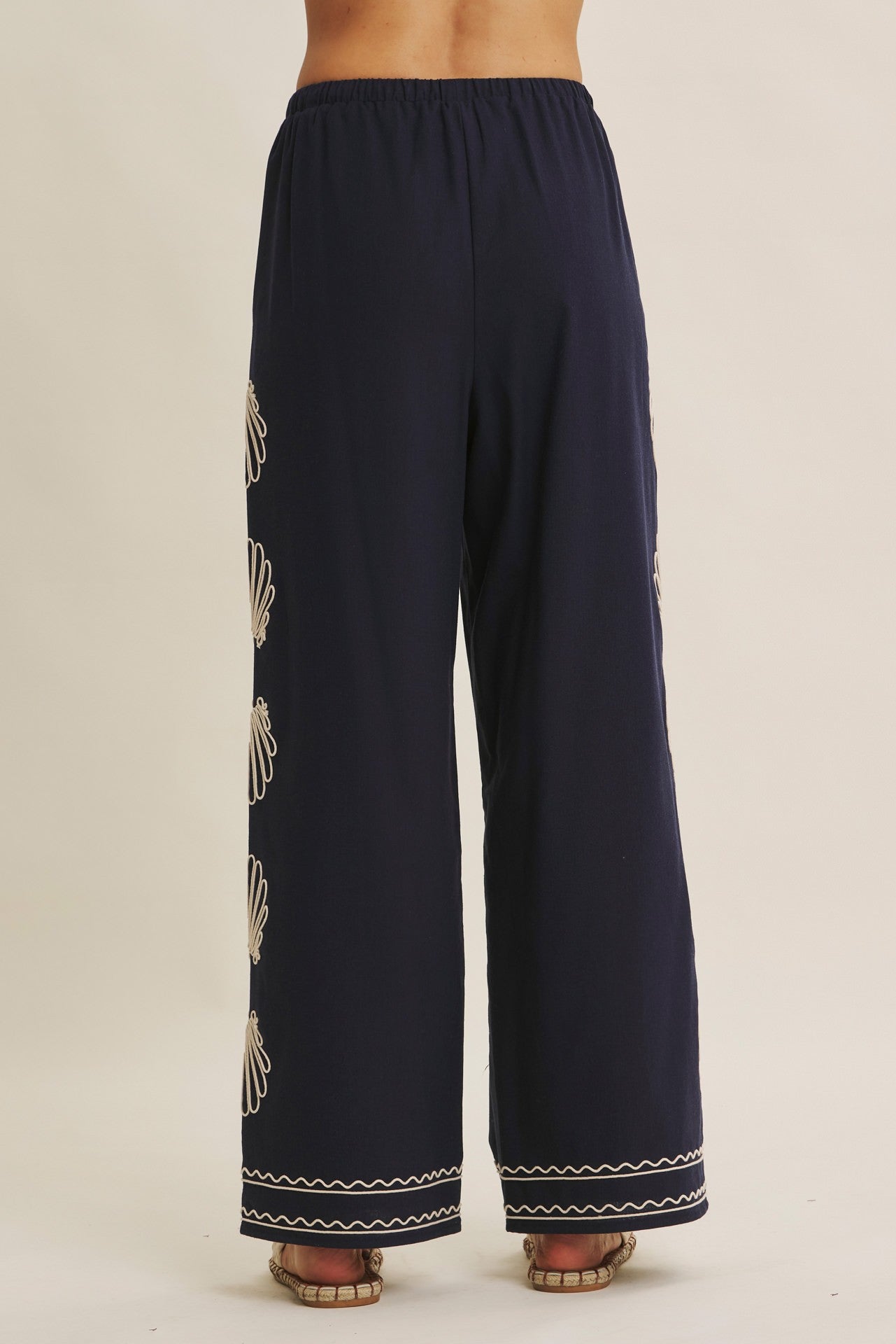 Navy wide-leg pants with seashell embroidery and drawstring waist by Chic Speak Boutique, styled for a casual, boho look.