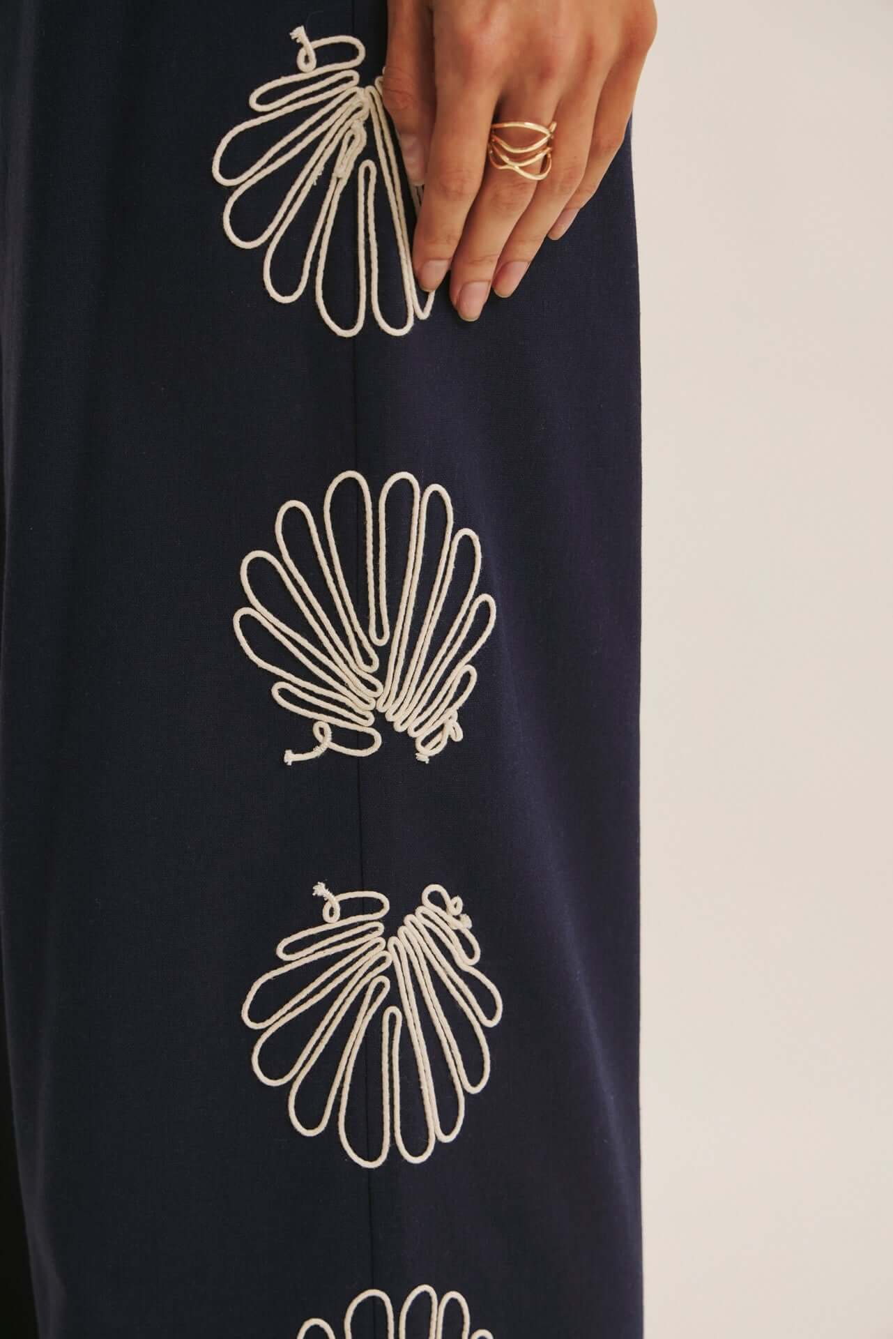 Navy seashell-embroidered wide-leg pants from Chic Speak Boutique featuring relaxed fit and flowing fabric.