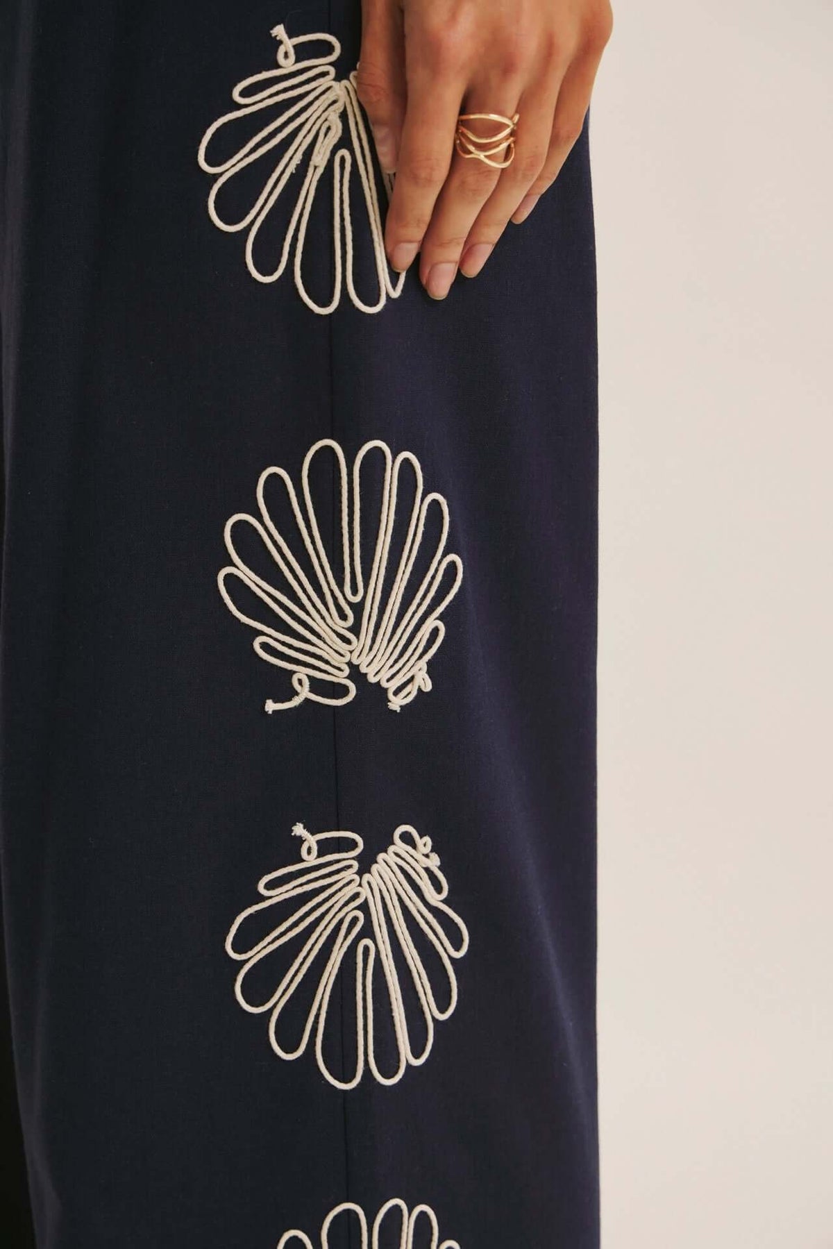 Navy seashell-embroidered wide-leg pants from Chic Speak Boutique featuring relaxed fit and flowing fabric.