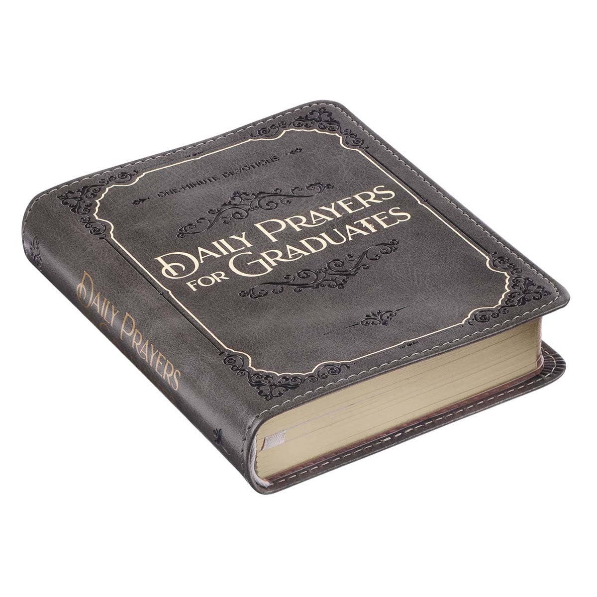 Faux leather devotional book titled "Daily Prayers for Graduates" from Christian Art Gifts, featuring gold-embossed lettering on cover.