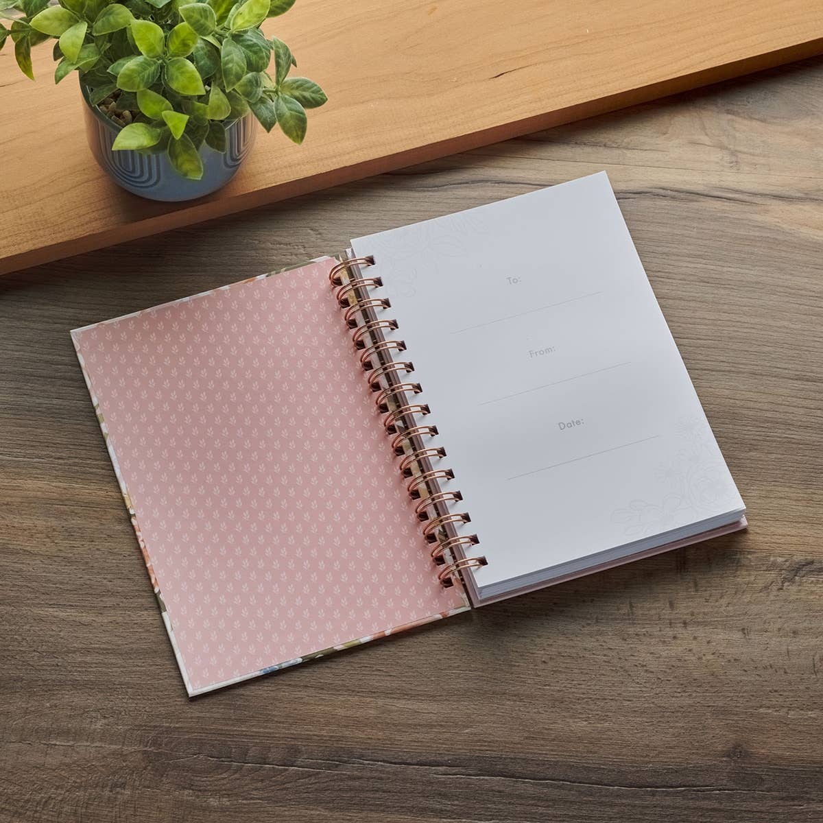 Wirebound pink floral journal with inspirational Christian art and Bible verse Proverbs 31:25, featuring elegant floral cover design.
