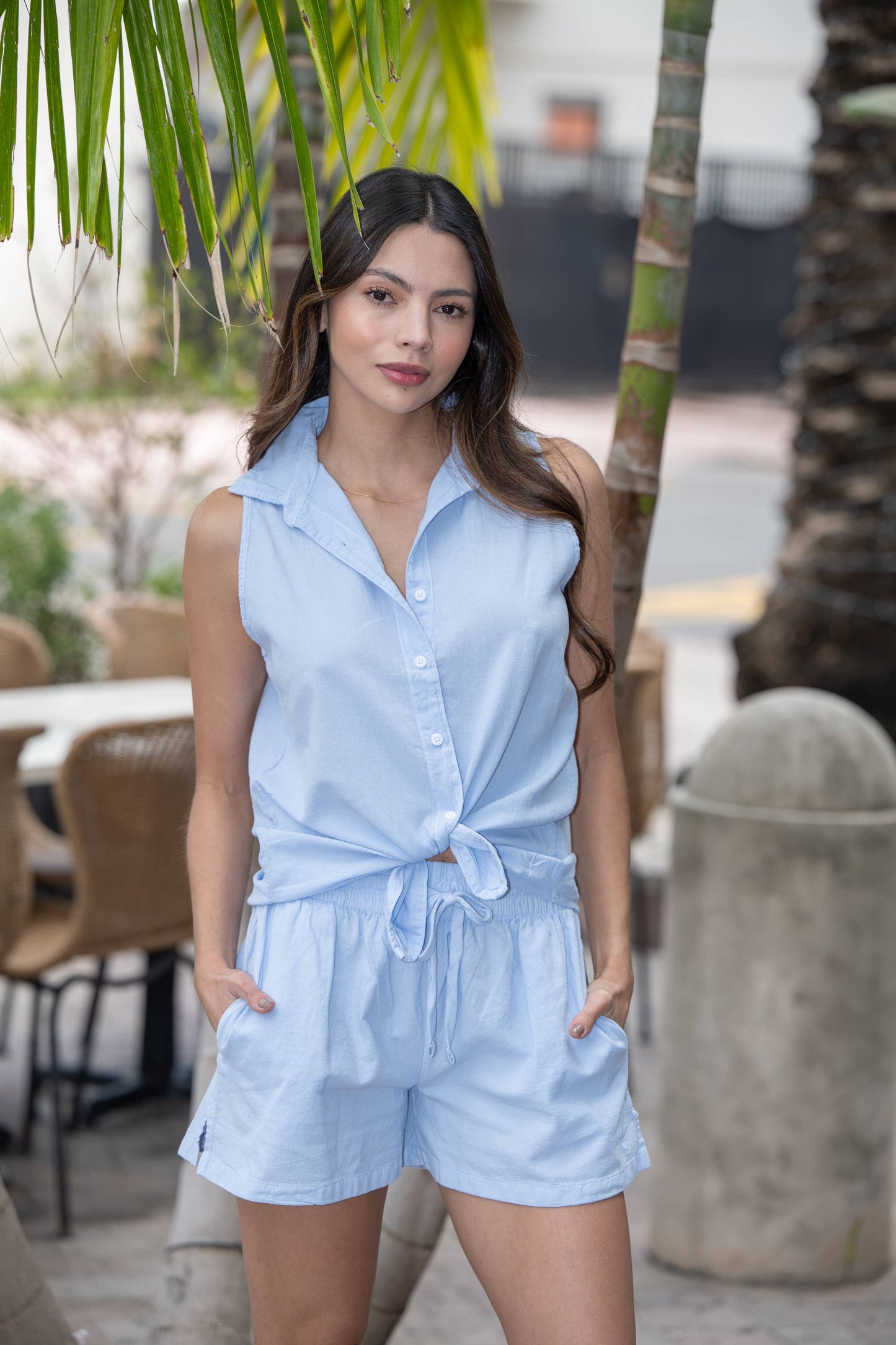Astra women's sleeveless high-low button-up cotton top by Cotton Natural, shown on a hanger with front and back views.