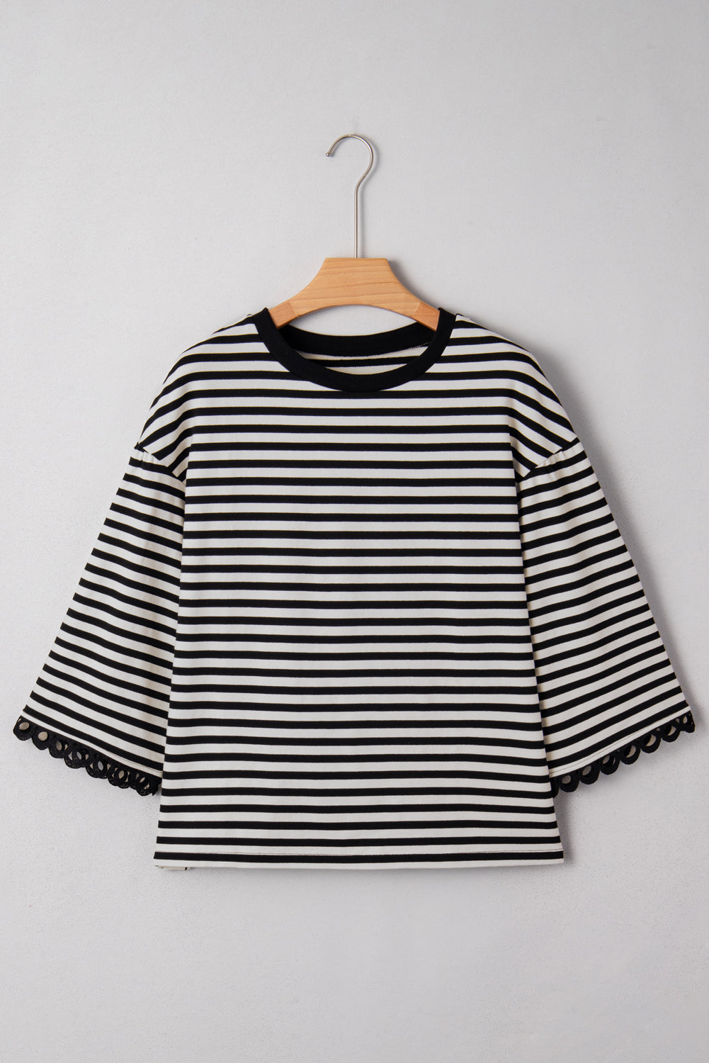Black striped bell sleeve top by CSB Private Label featuring flowy sleeves and a relaxed fit on a model.