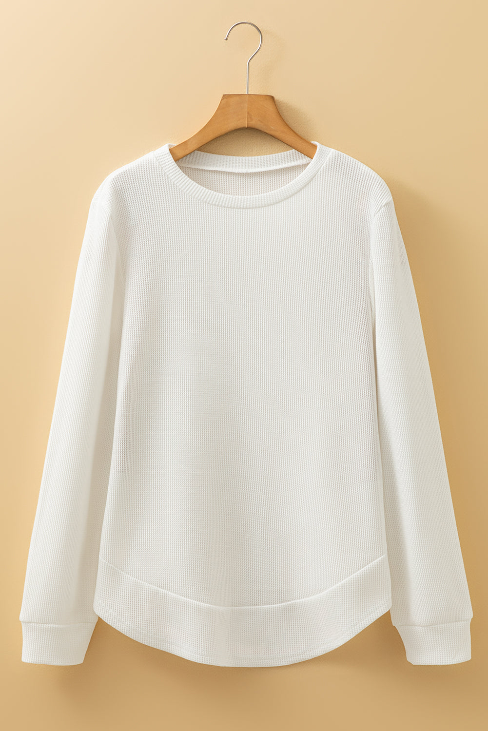 White long-sleeve waffle top with rounded hem from CSB Private Label, showcasing the textured fabric and relaxed fit.