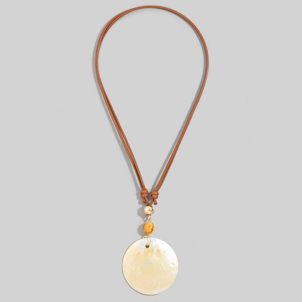 Necklace with a round beige pendant on a brown cord against a gray background