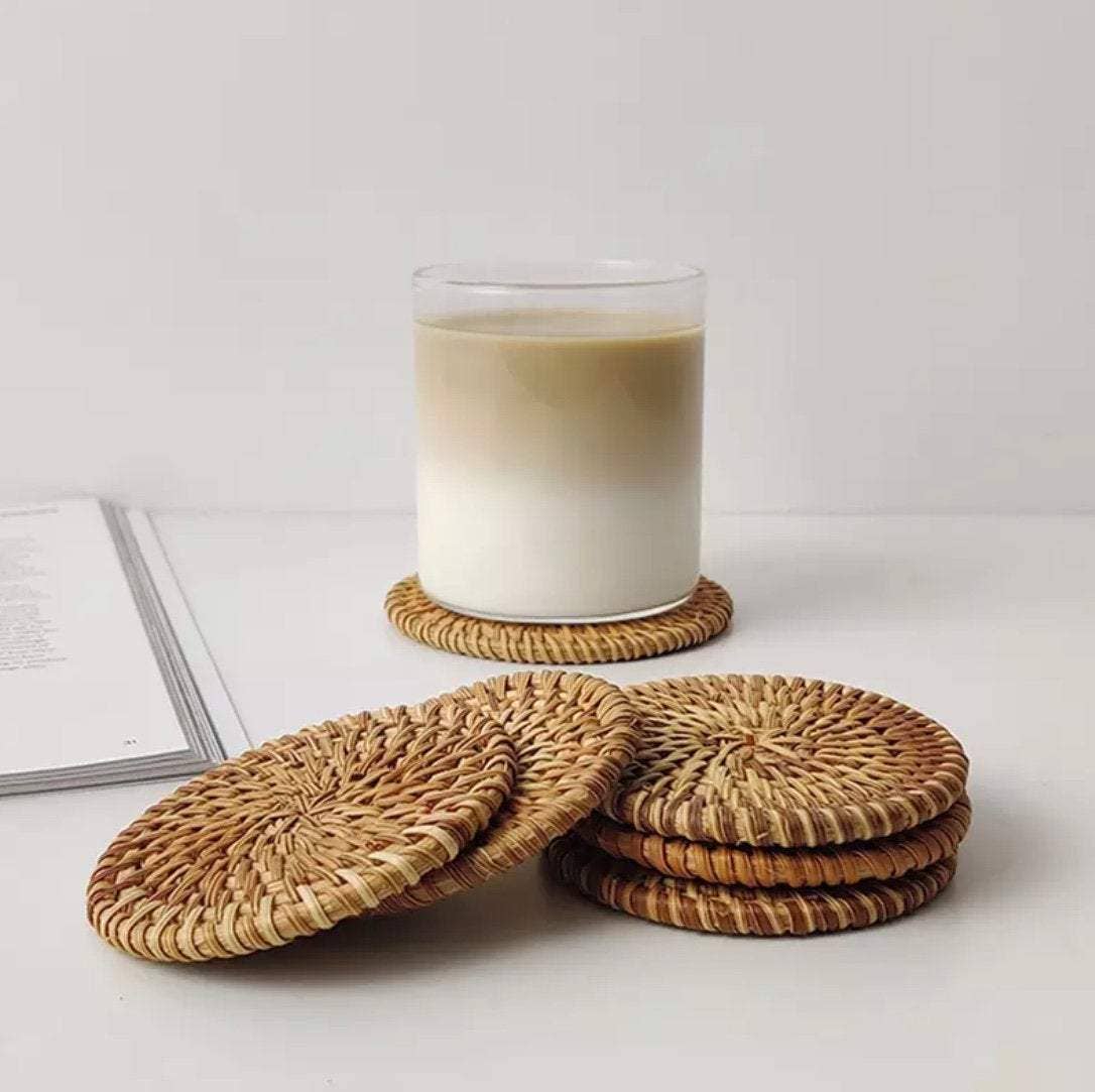 Set of natural rattan coasters by Delmar Decor showing round, woven rattan surface with a smooth finish.