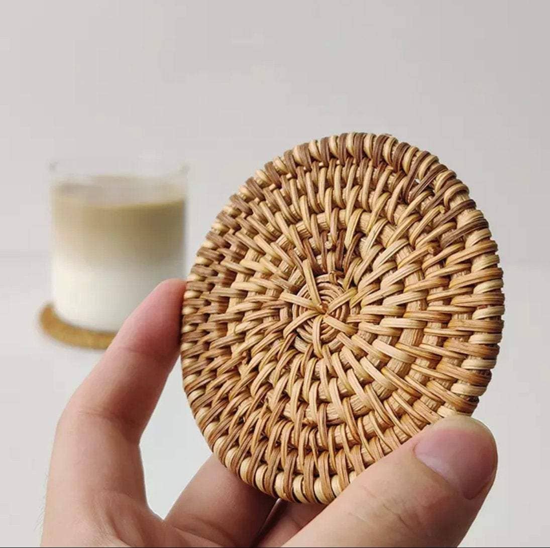Set of natural rattan coasters from Delmar Decor with woven design for protecting surfaces and adding rustic charm.