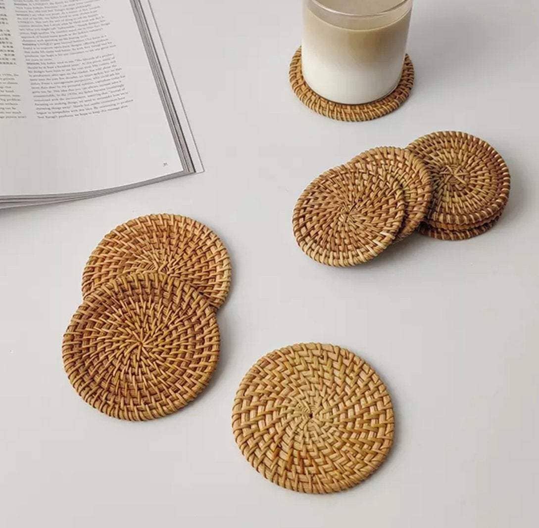 Set of natural rattan coasters by Delmar Decor, round woven drink coasters with a rustic, textured appearance.