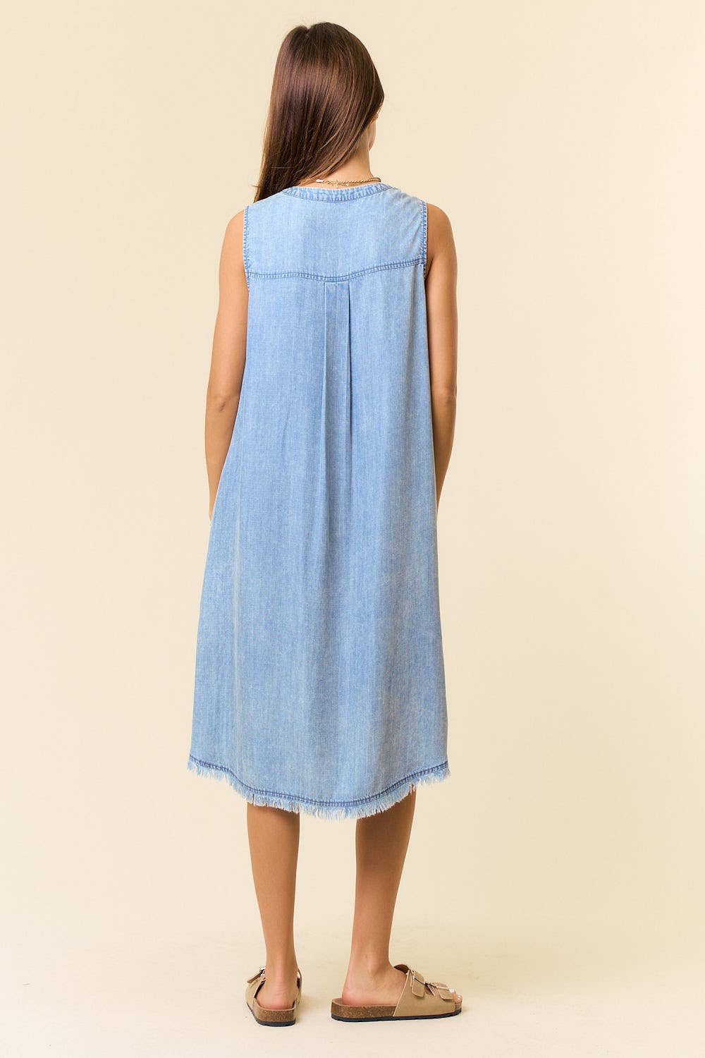 Tencel denim knee-length sleeveless Henley dress by Doe and Rae, showing the front view with button details and sleeveless design.
