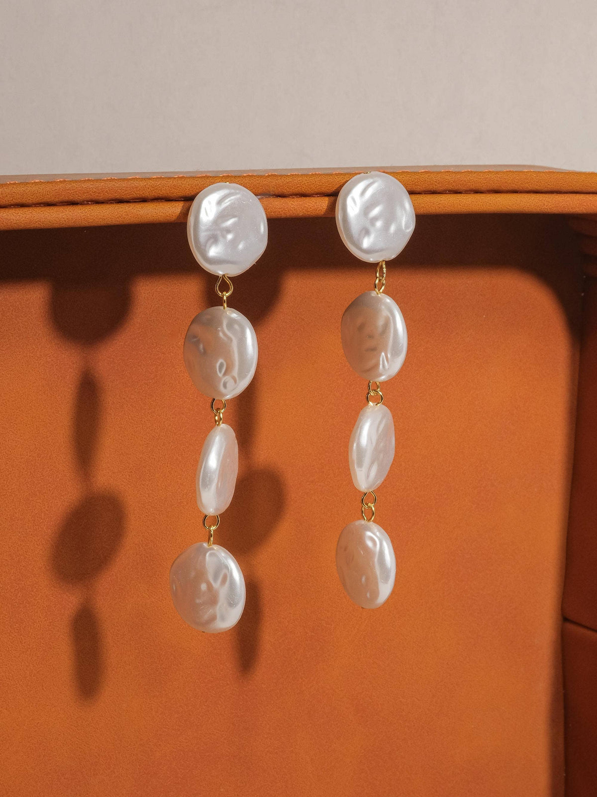 18K non-tarnish pearl drop earring by Flanerie by MAIQ featuring a elegant pearl pendant hanging from a sleek gold-tone hook.