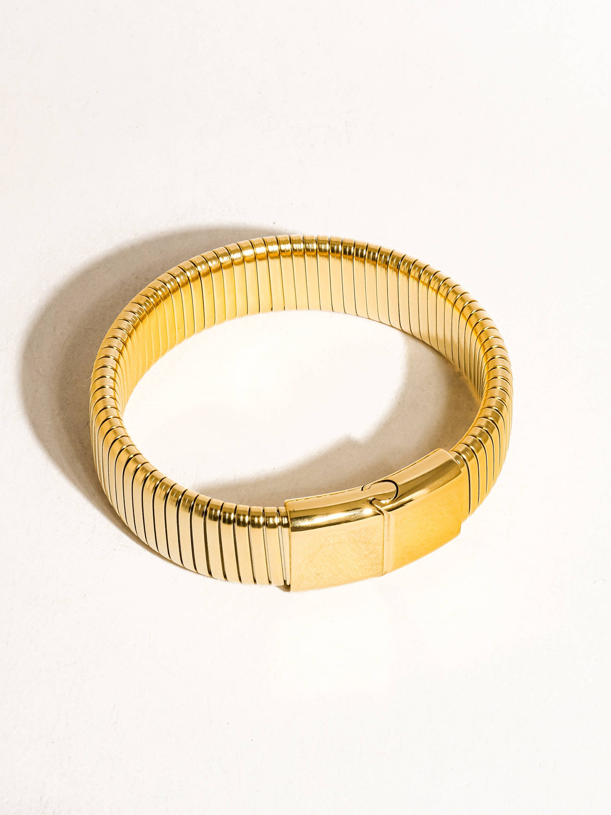 Christel 18K gold non-tarnish stripe bold bangle by Flanerie by MAIQ, featuring a striking gold and white striped design.