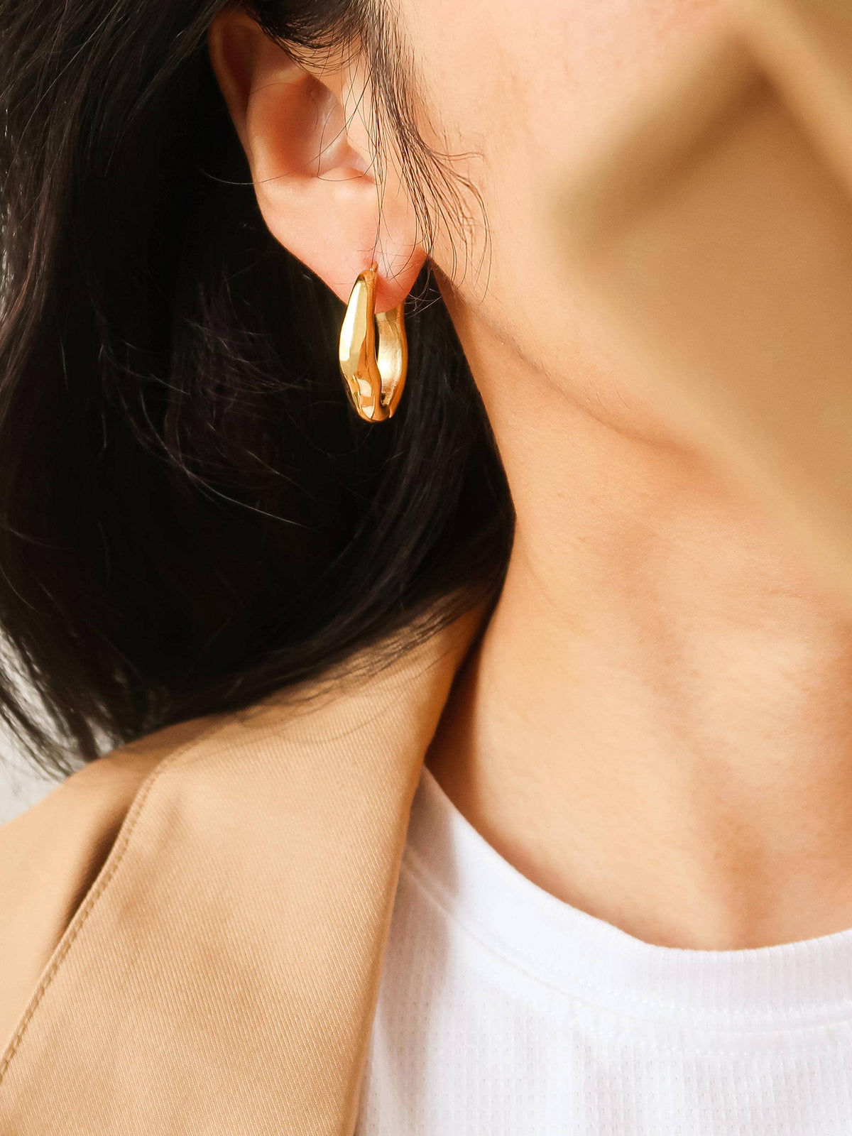 Flanerie by MAIQ Darcy 18K gold non-tarnish oval hoop earring with polished finish and secure clasp design.