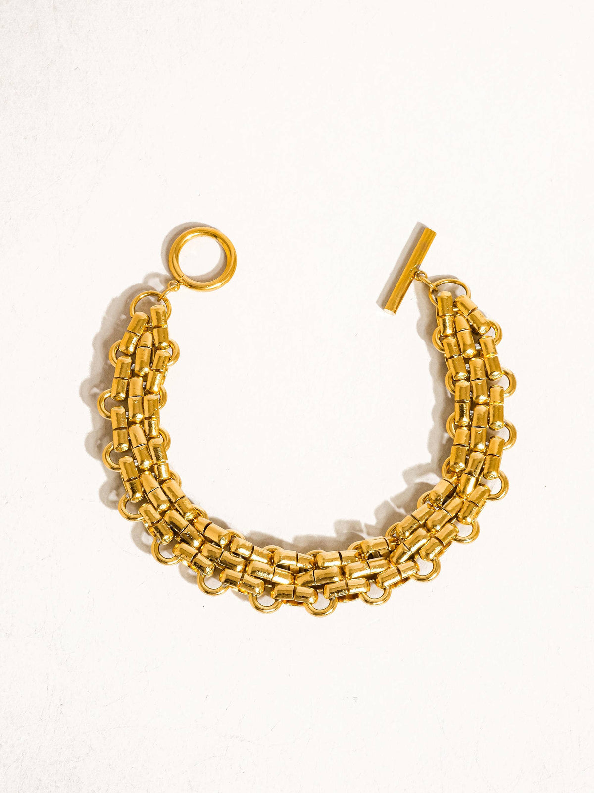 Donni 18K gold non-tarnish bold weave bracelet with intricate design, showcasing a luxurious gold finish and sturdy craftsmanship.