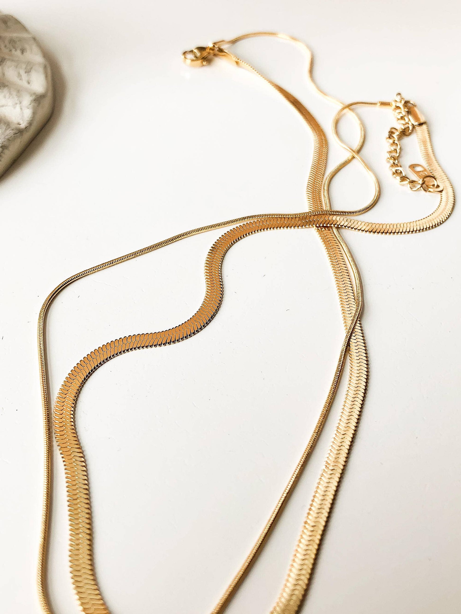 18K gold layered snake chain necklace by Flanerie, non-tarnish flat snake design, close-up of the elegant jewelry piece