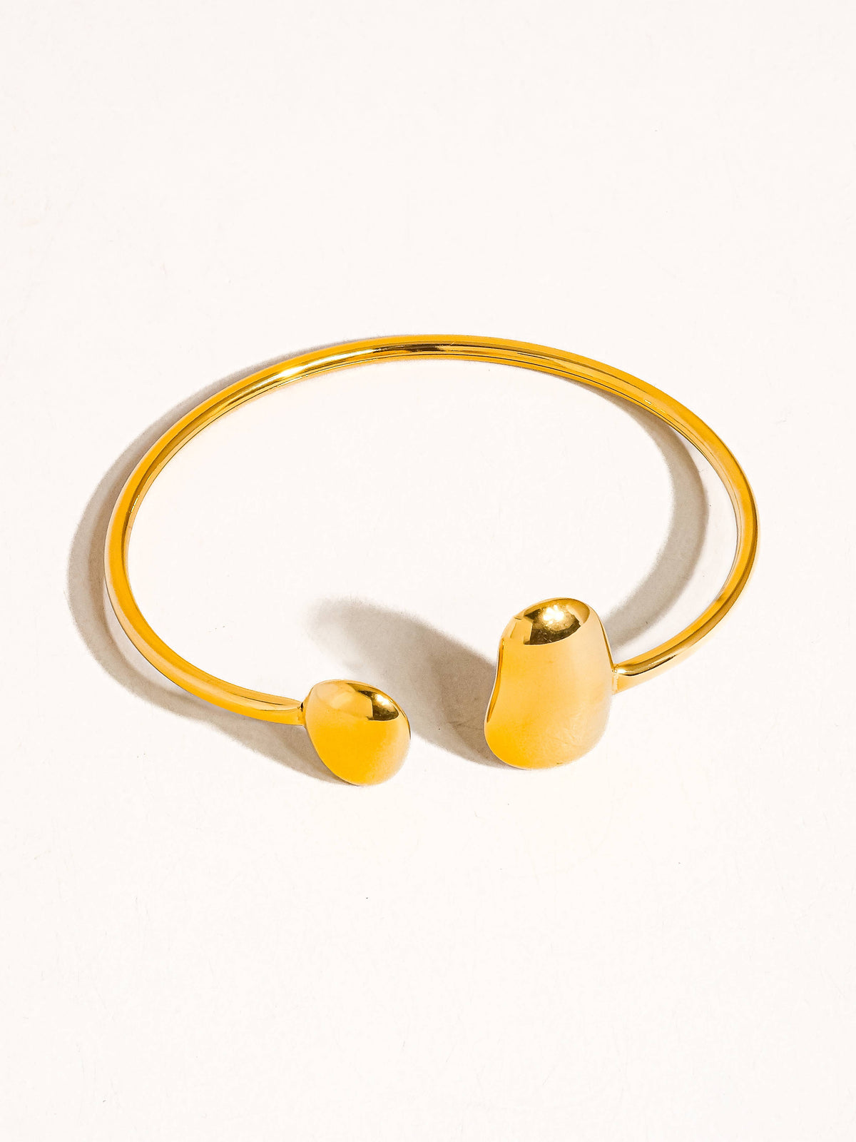 Close-up of Mazie 18K non-tarnish round thin bracelet by Flanerie by MAIQ, showing its delicate, polished gold finish.